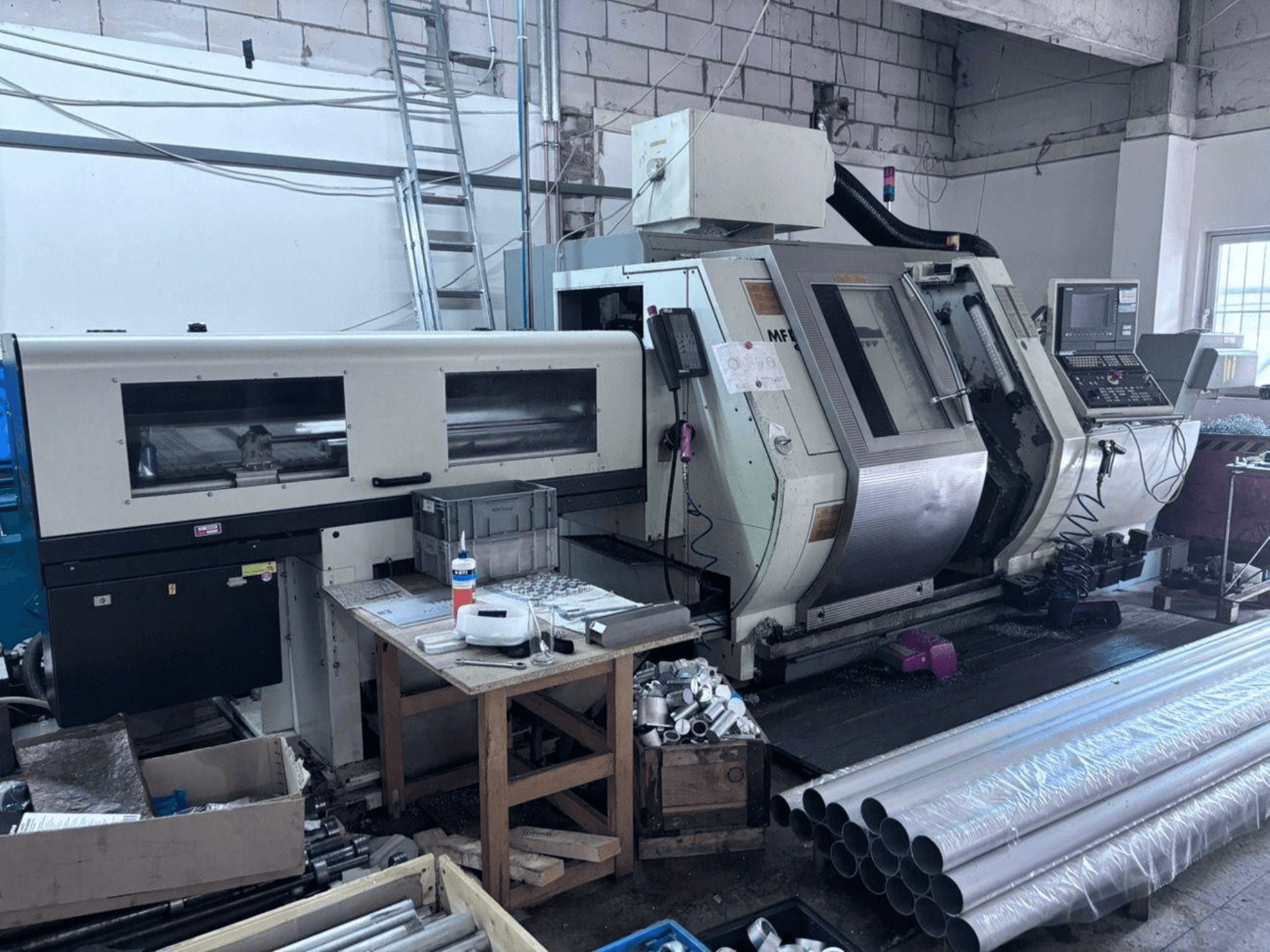 Centro de torneado y fresado Gildemeister MF Twin 65, vista lateral en la que se aprecian el panel de control, la zona de mecanizado y los tubos de aluminio.