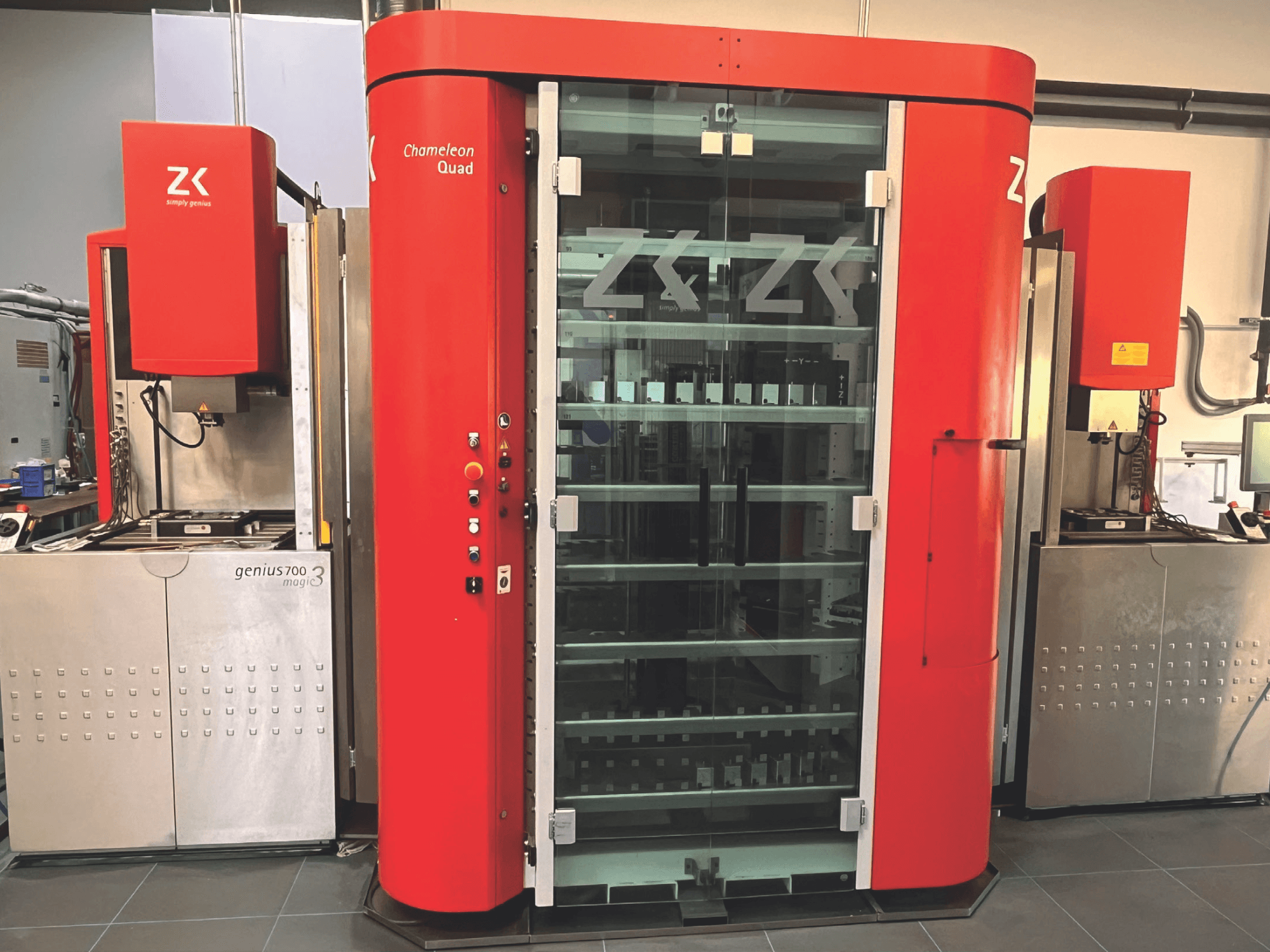 ZK Chameleon Quad, vista frontal, con exterior rojo, estantes de cristal y unidad adyacente Genius 700 Magic 3 con panel de control.