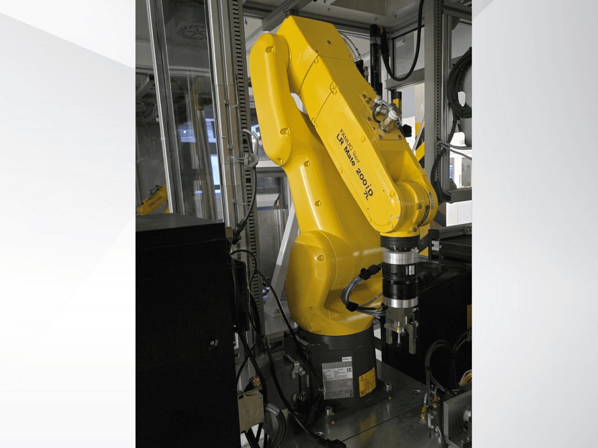 Brazo robótico Fanuc LR Mate 200iD amarillo mostrado desde una vista lateral, con una pinza y varios cables conectados.