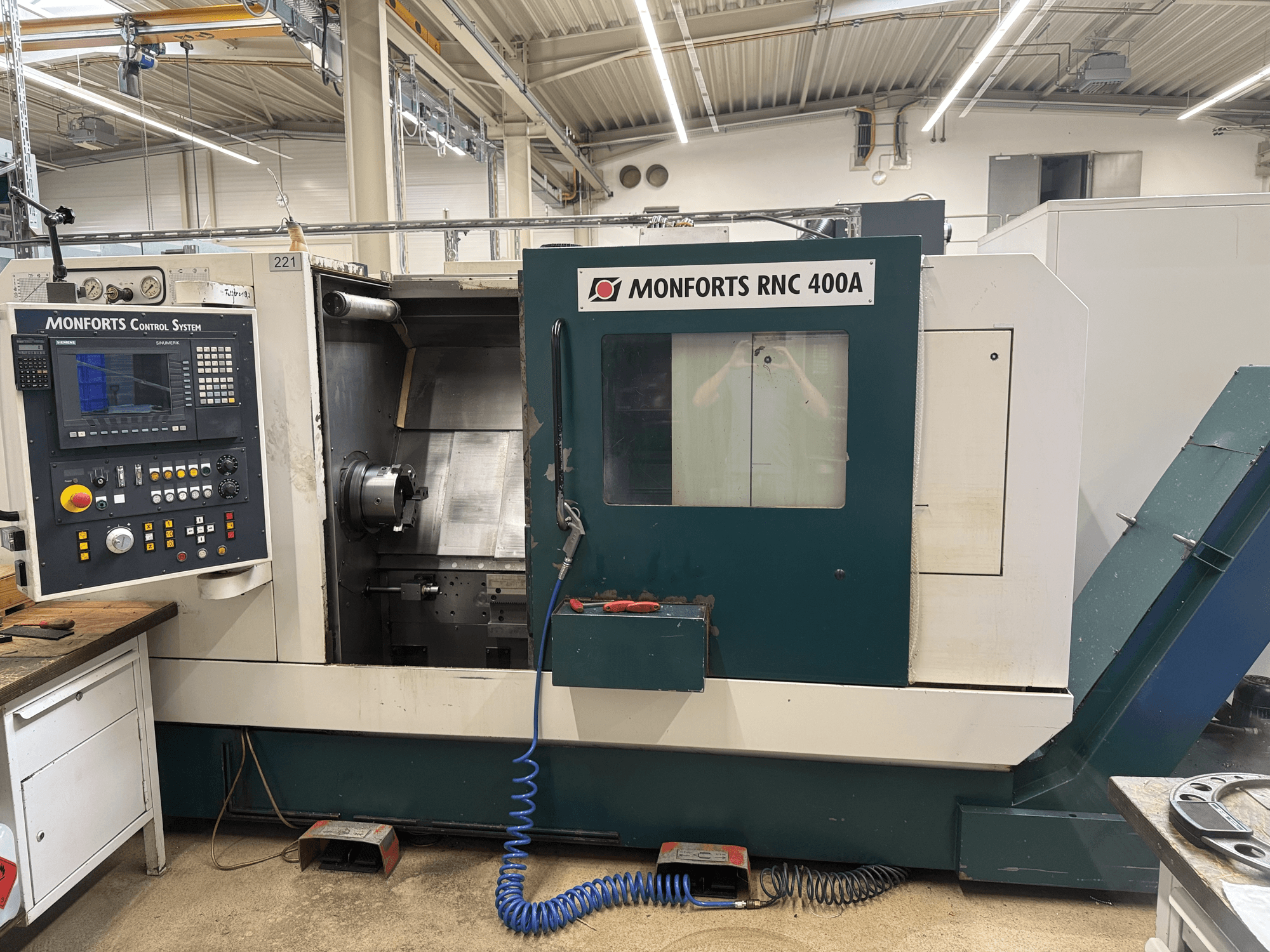 Torno horizontal Monforts RNC 400 A, vista frontal, en la que se aprecian el panel de control y el interior de la máquina.