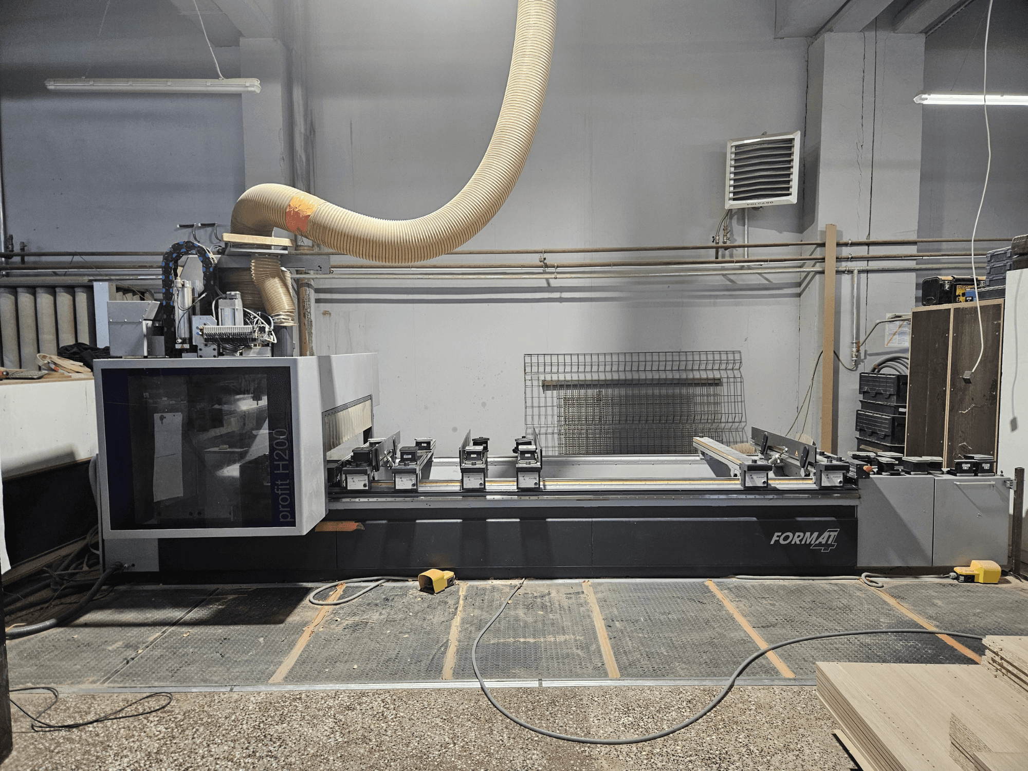 Una máquina CNC FORMAT profit H200 en un taller, vista lateral, mostrando la superficie de trabajo y el sistema de extracción de polvo.