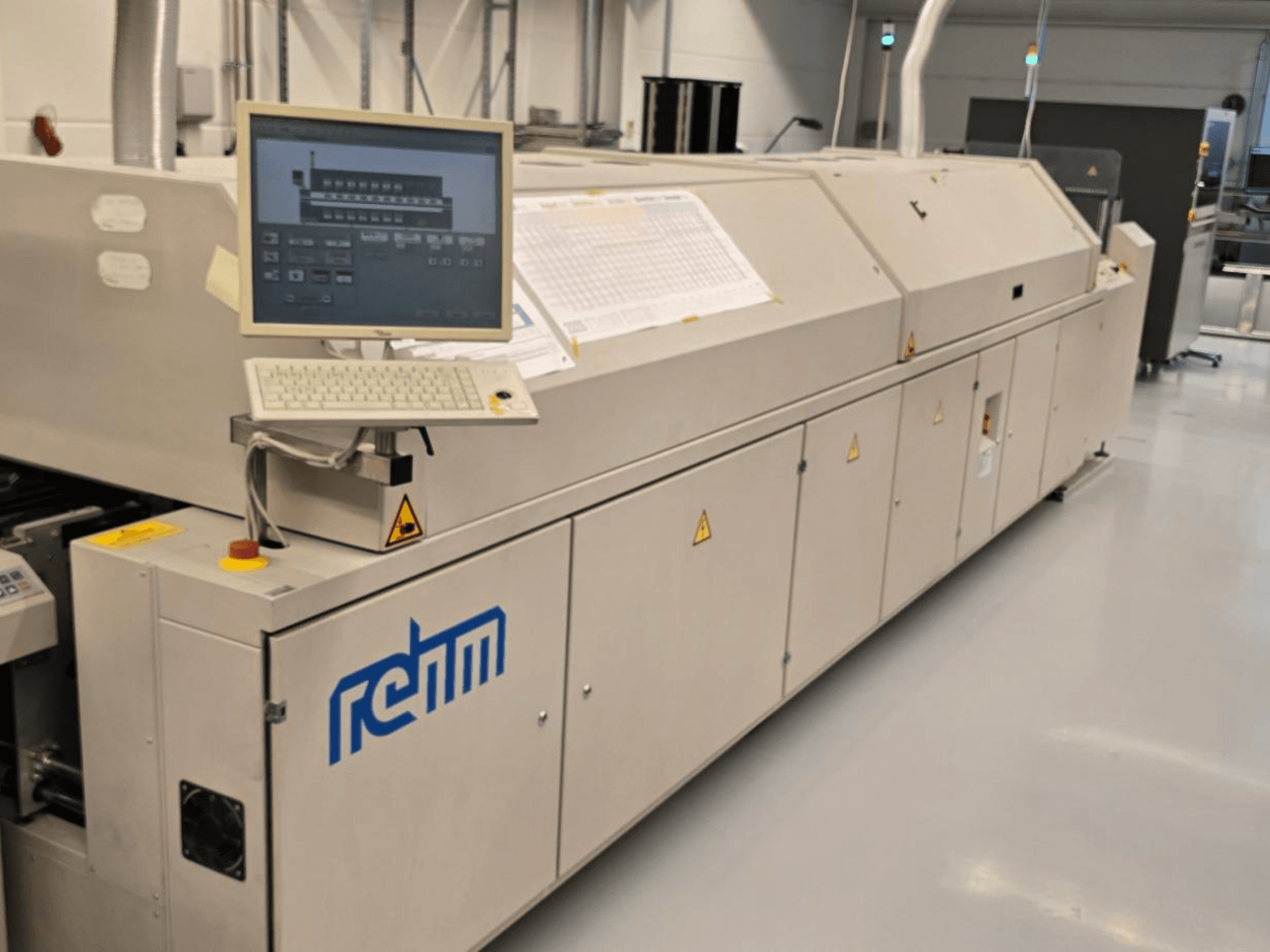 Equipo de automatización REHM VXS Nitro 2450, vista frontal; incluye monitor, teclado y panel de control para las operaciones.