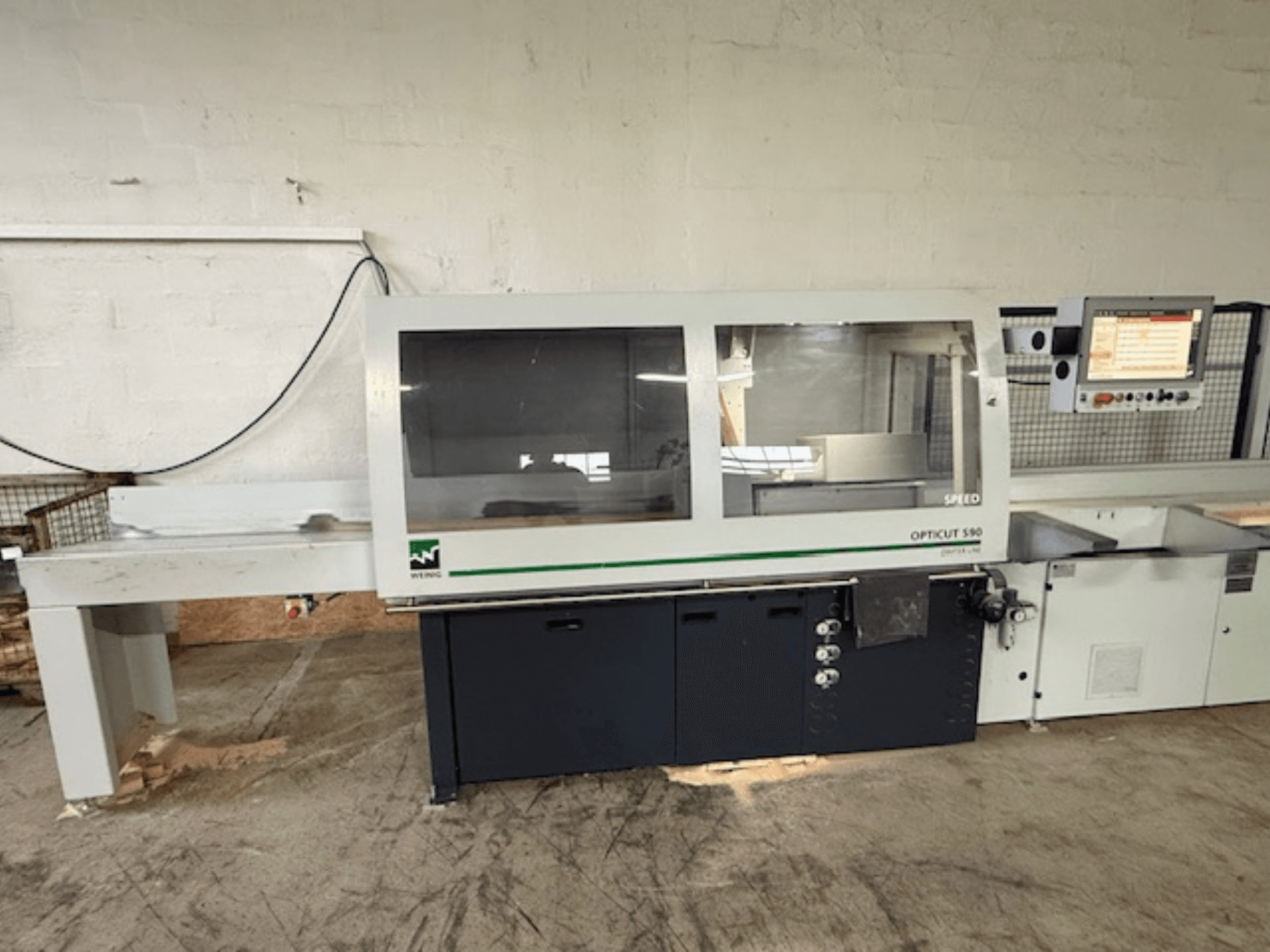 Sierra tronzadora optimizadora WEINIG OPTICUT S90, vista frontal mostrando el panel de control, la unidad de sierra y la mesa de alimentación.