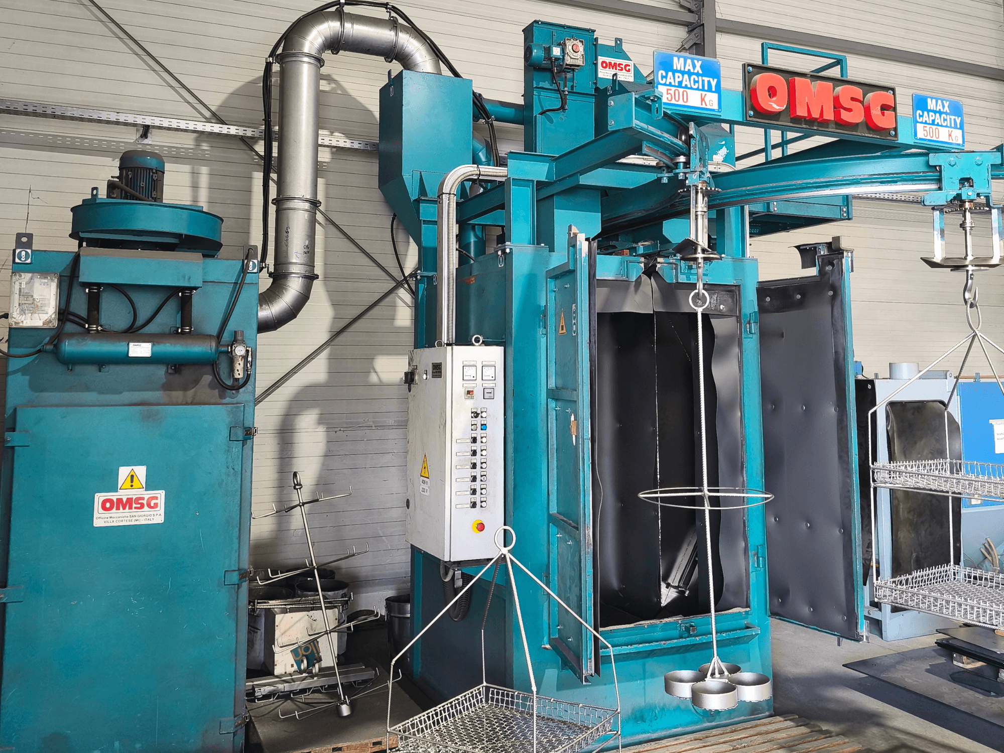 Máquina de limpieza industrial OMSG con una capacidad máxima de 500 kg, con panel de control y cámara abierta para la limpieza de piezas.