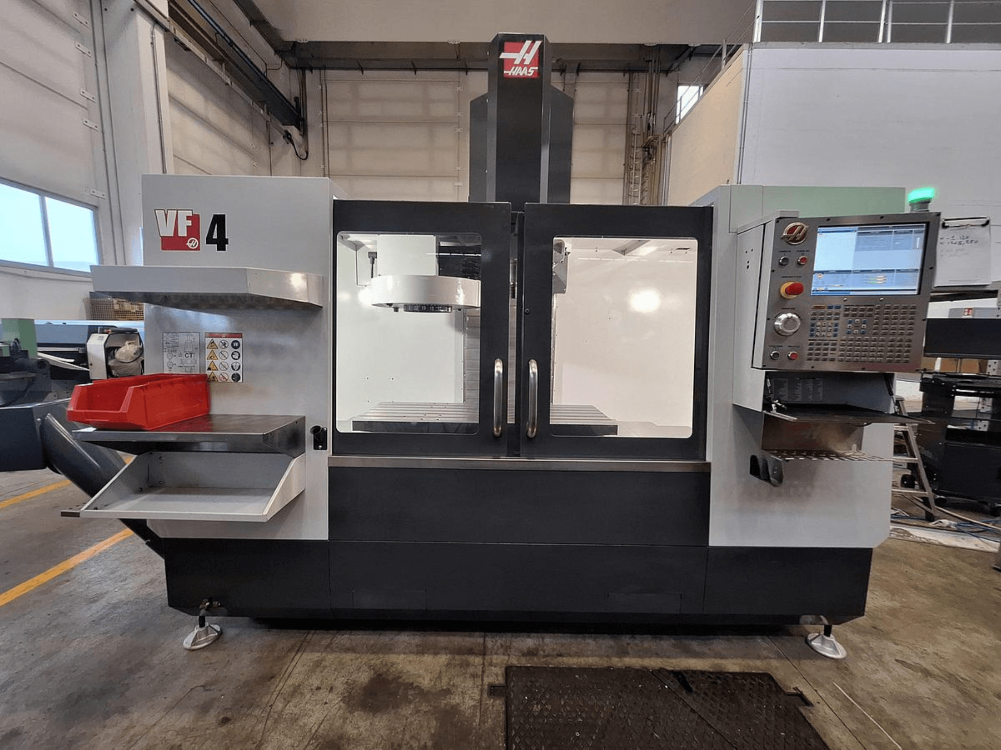 Centro de mecanizado vertical Haas VF-4, vista frontal, con panel de control, portaherramientas y amplia zona de trabajo.