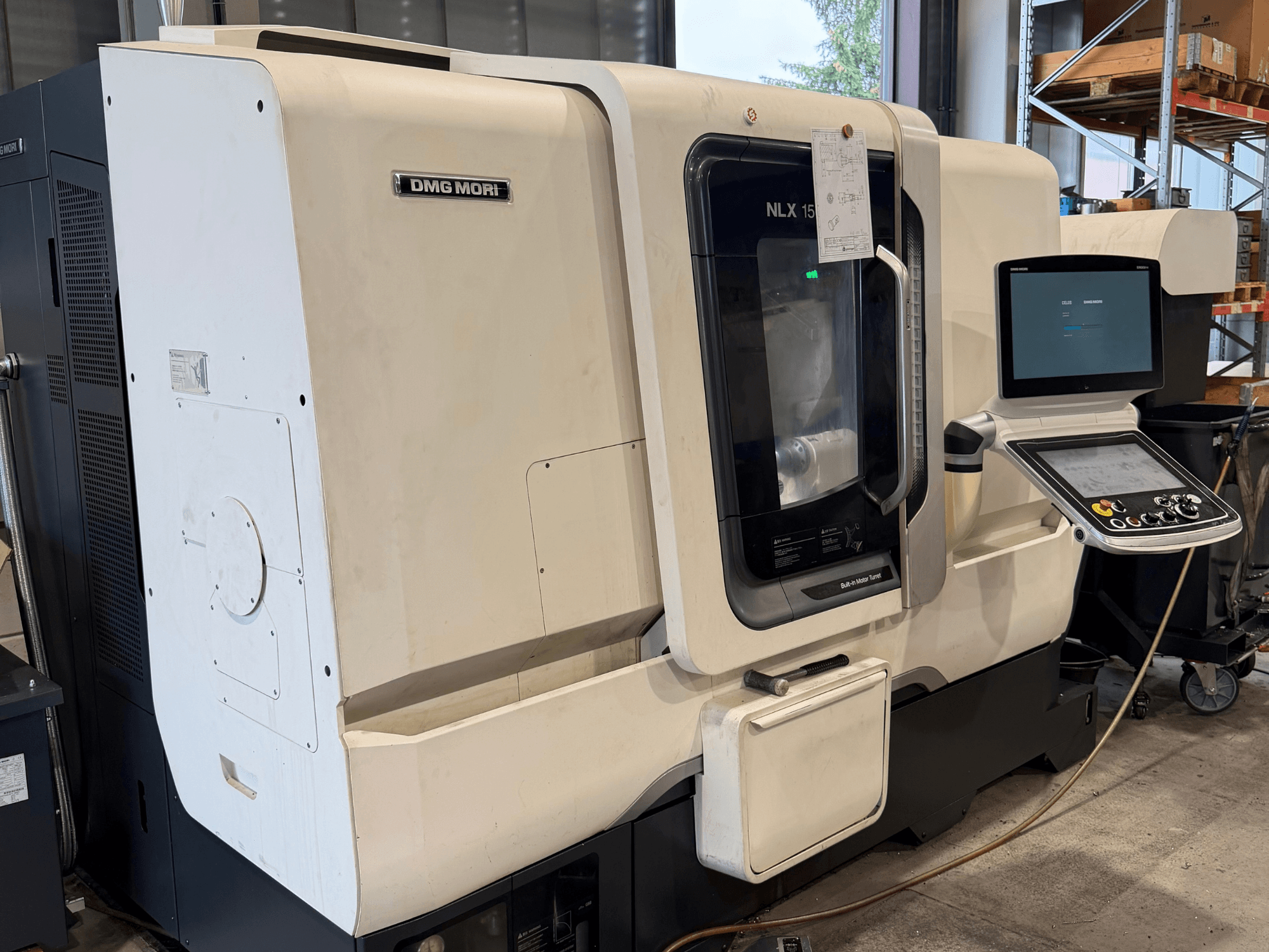 Vista frontal del torno horizontal DMG MORI NLX1500MC/500, en la que se aprecian el panel de control y la zona del husillo a través de la cubierta transparente.