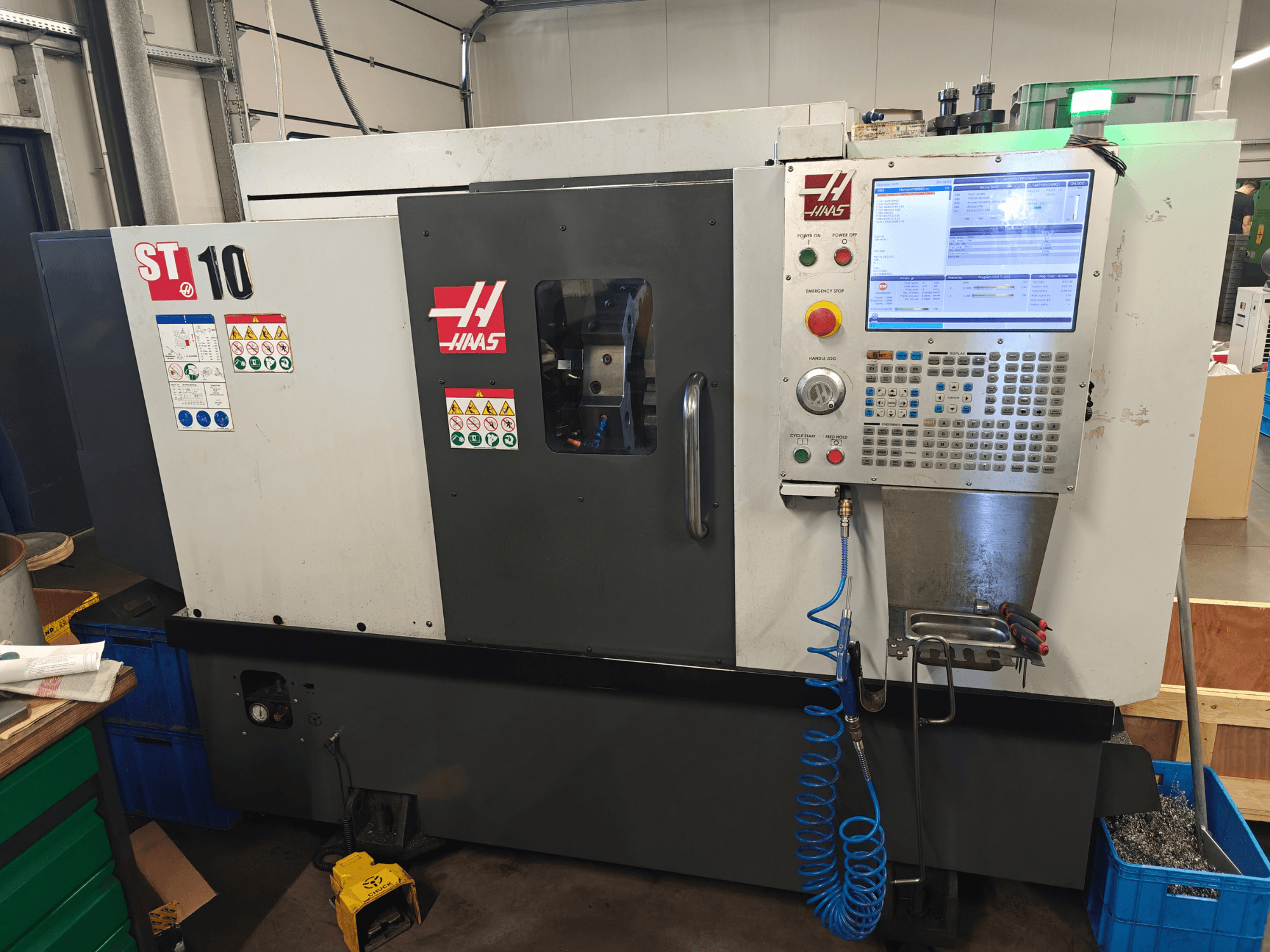 Torno horizontal Haas ST-10, vista frontal, en la que se aprecian el panel de control, las etiquetas de seguridad y la estructura de la máquina.