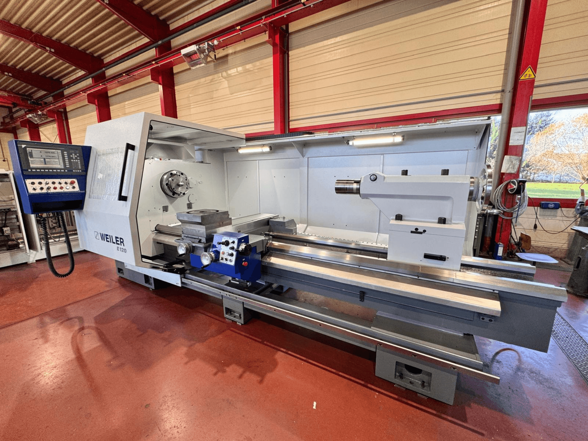 Torno Weiler E120, vista frontal, dispone de panel de control, husillo giratorio y bancada de precisión con guías lineales.