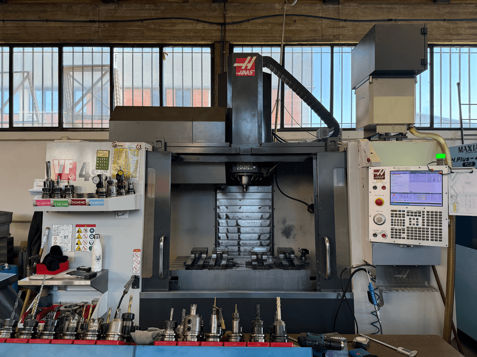 Centro de mecanizado vertical HAAS VF-4SS, vista frontal, en la que se aprecian el panel de control, los portaherramientas y la zona del husillo.