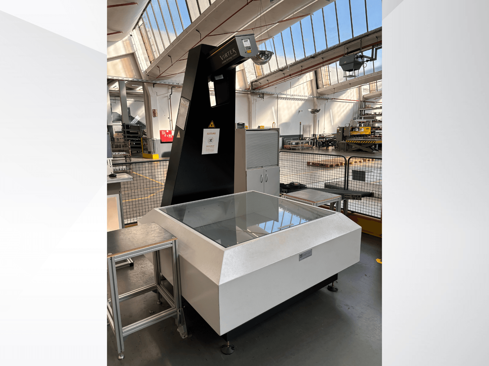 Máquina de medición óptica VIRTEK LPS-1EA en un entorno industrial; vista frontal en la que se aprecian la superficie de cristal y el panel de control.
