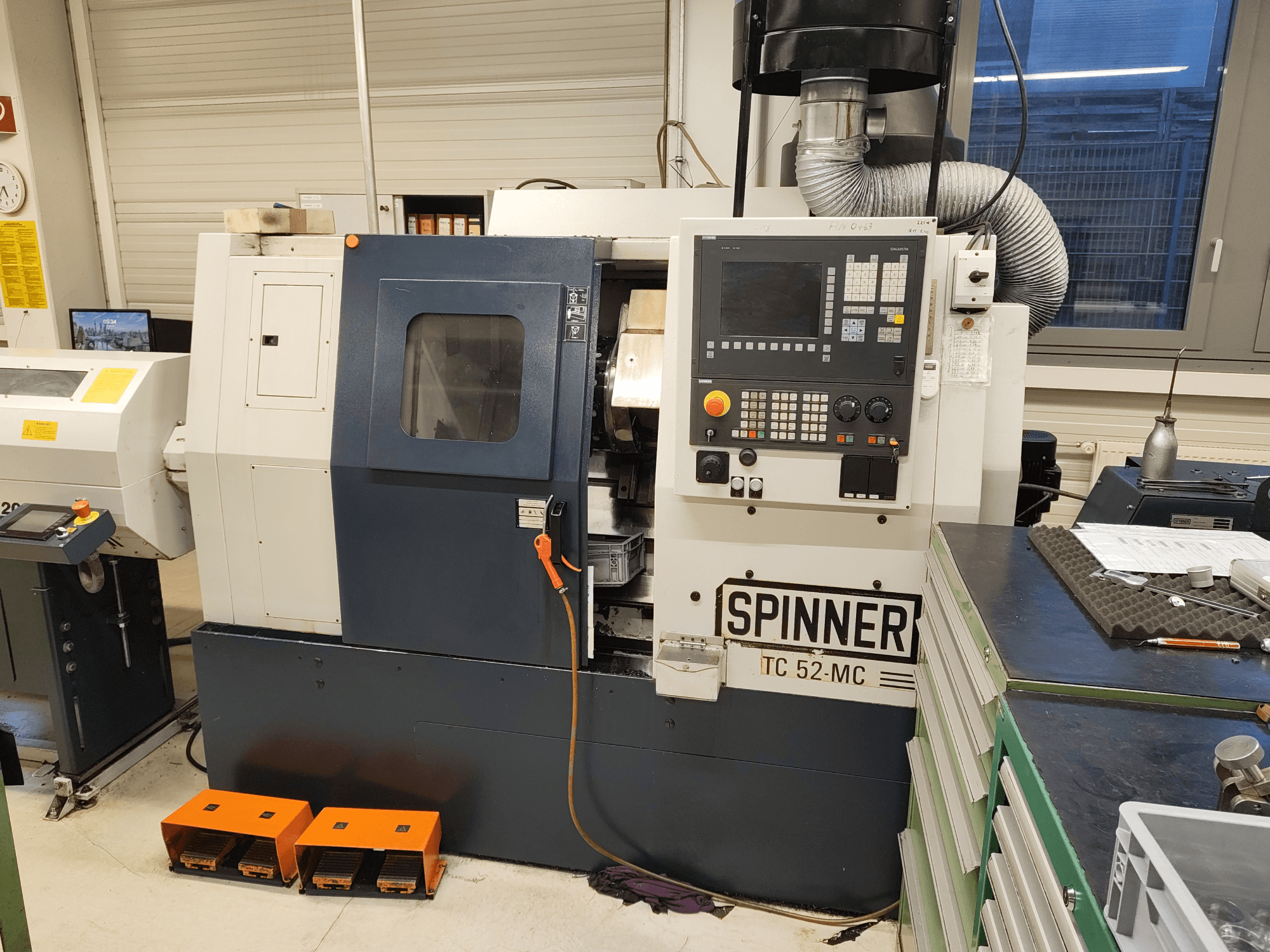 Torno horizontal SPINNER TC 52 MC en un taller, vista frontal, en la que se aprecian el panel de control, la zona de mecanizado y los dispositivos de seguridad.