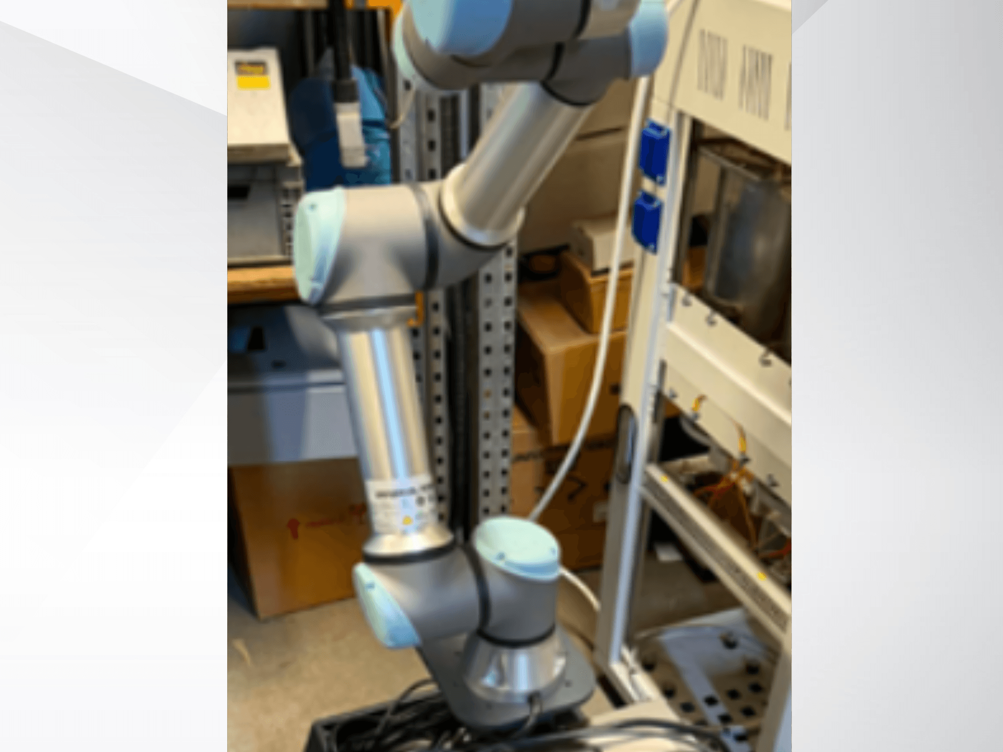 Brazo robótico UR5e de Universal Robots visto de perfil, en el que se aprecian las articulaciones, su diseño ligero y los cables de control.