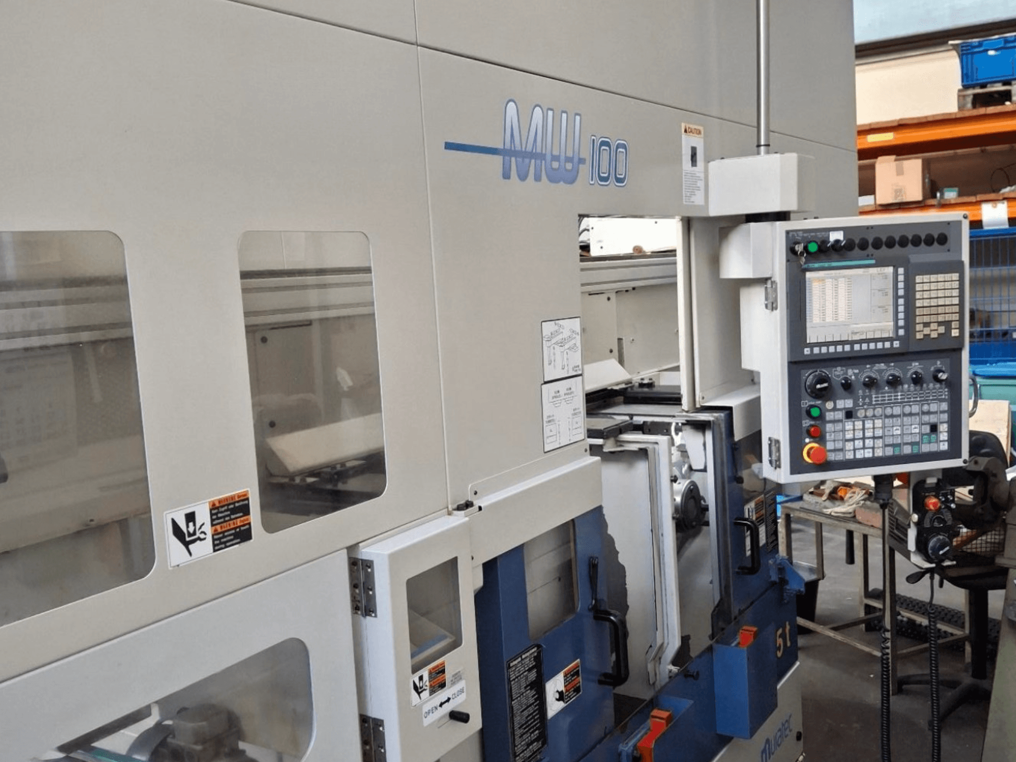 Máquina de torneado multihusillo Muratec MW 100 GT, vista frontal, mostrando el panel de control y los compartimentos de la máquina.