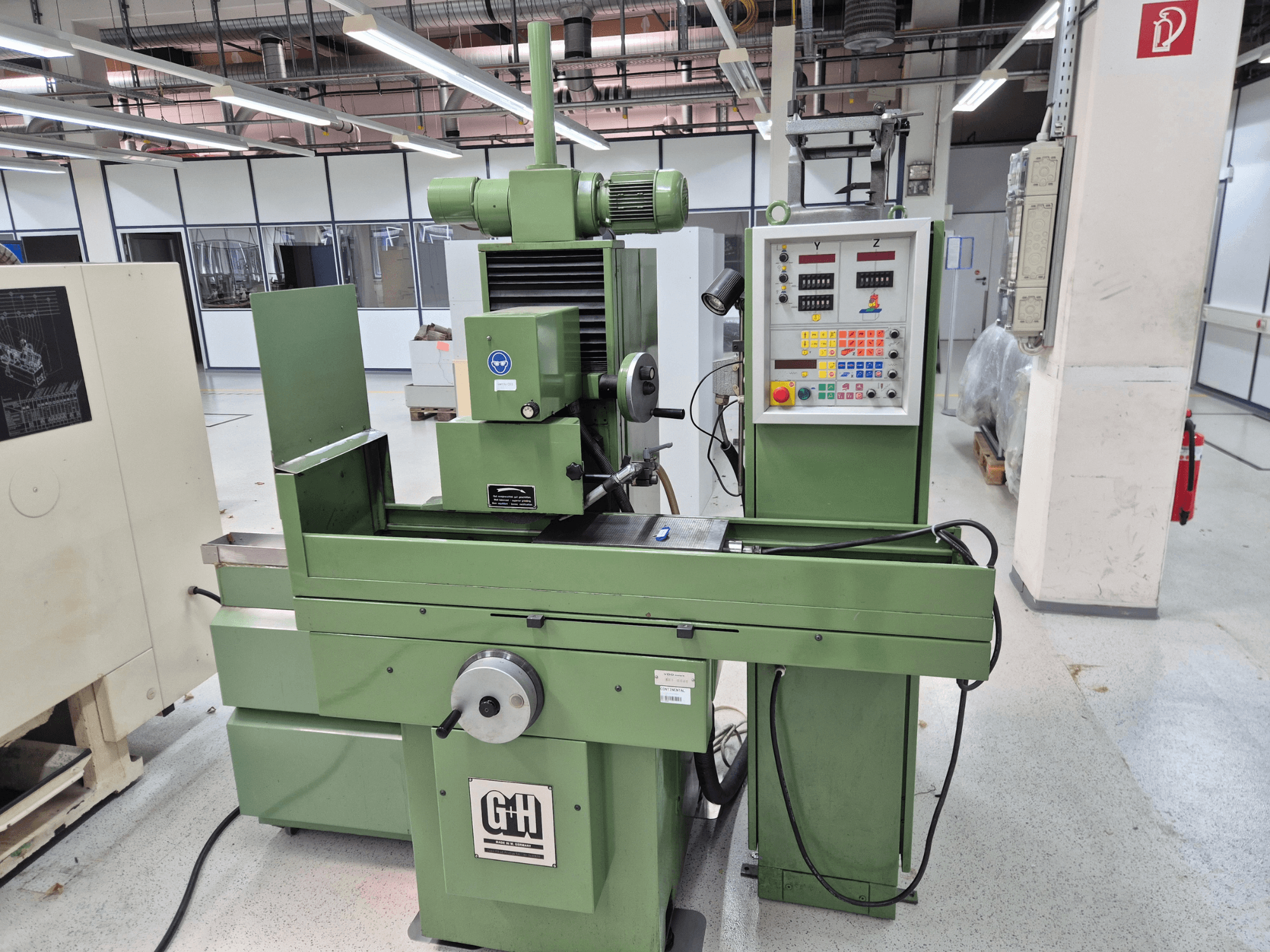 Rectificadora plana GEIBEL & HOTZ FS 40 SA en un taller, en la que se aprecian, en una vista frontal, el panel de control, la mesa de rectificado y el motor.