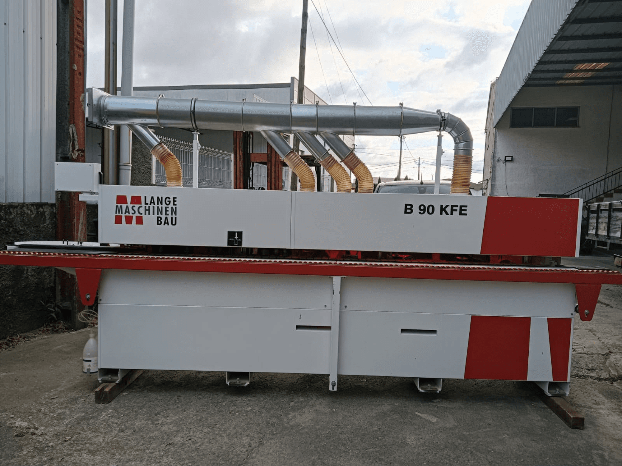 Cantadora LANGE Maschinenbau B 90 KFE vista de perfil, con dos tubos de escape y detalles en rojo, instalada en un espacio de trabajo industrial.