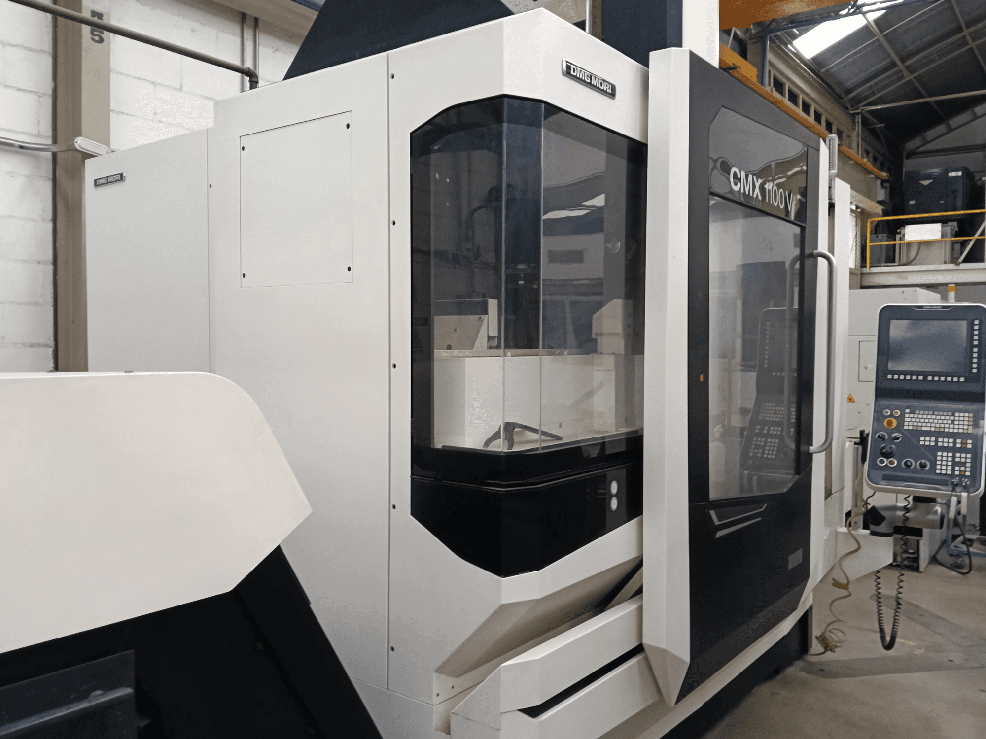 Centro de mecanizado vertical DMG MORI MORI CMX 1100 V, vista frontal, en la que se aprecian el panel de control y la cubierta de cristal.