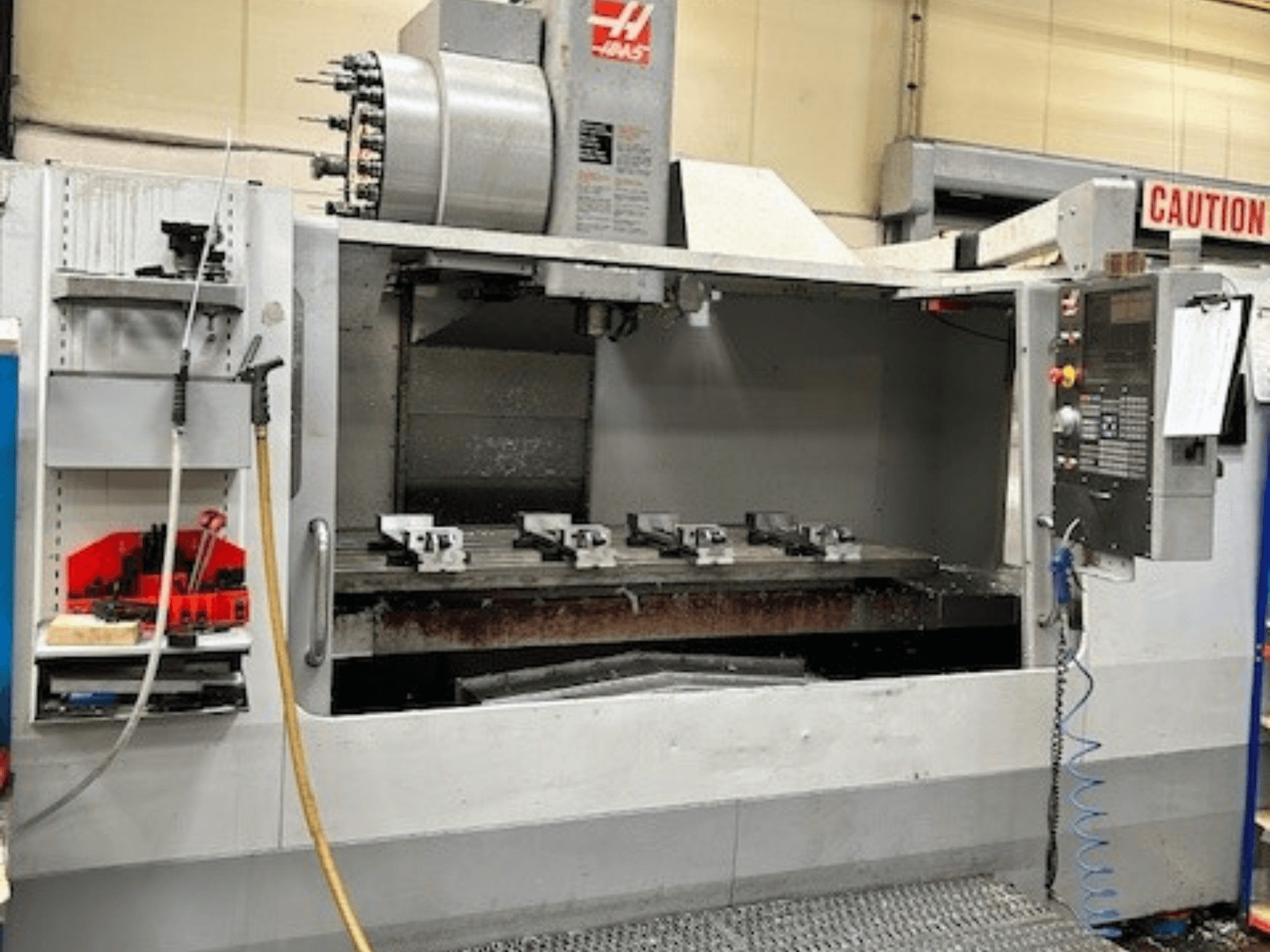 Centro de mecanizado vertical HAAS VF-9/40HE, vista frontal, con portaherramientas y accesorios visibles en el lateral.