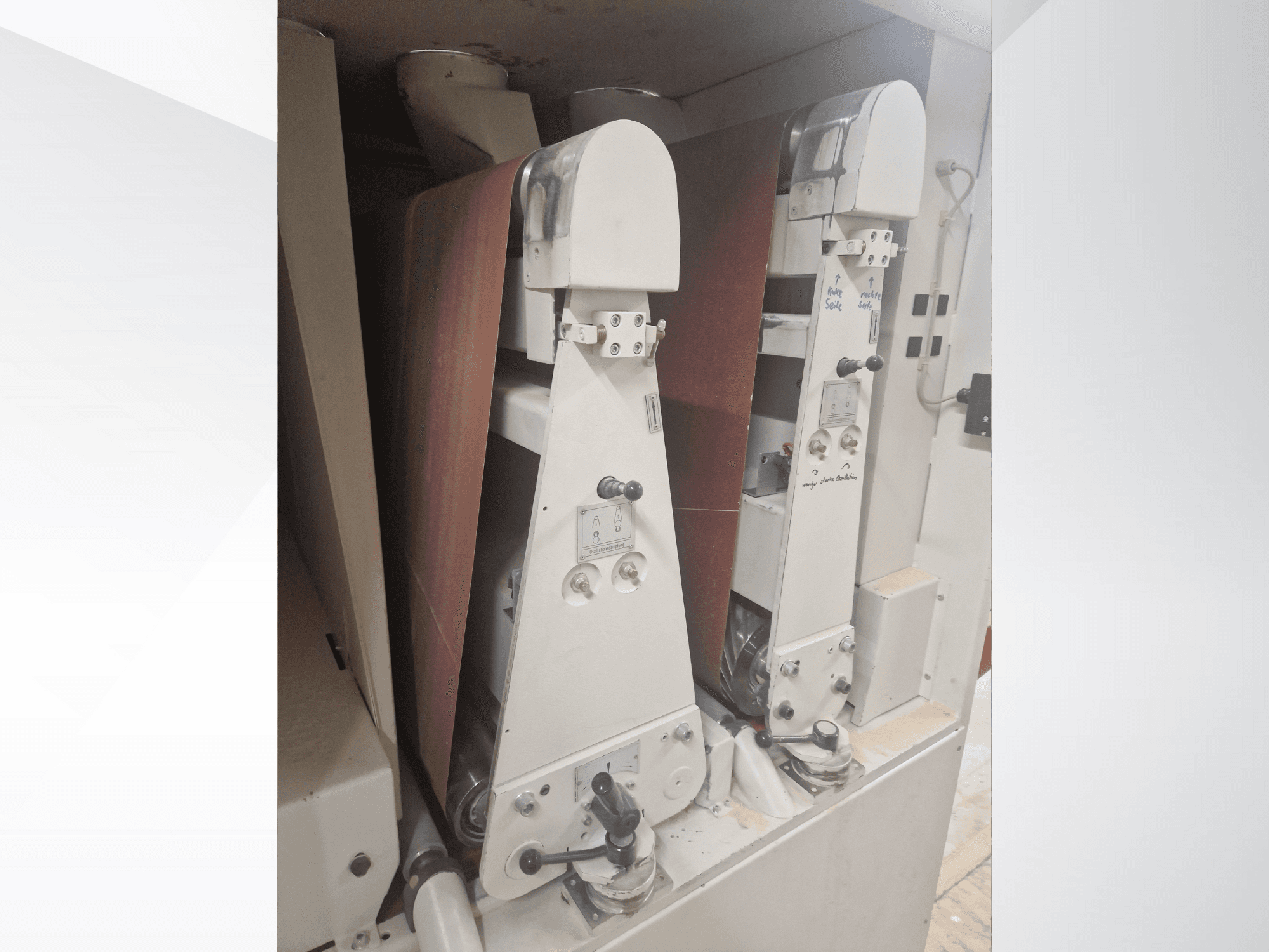 Dos lijadoras industriales con bandas de lijado rojas, vista frontal, mostrando los controles y los componentes metálicos.