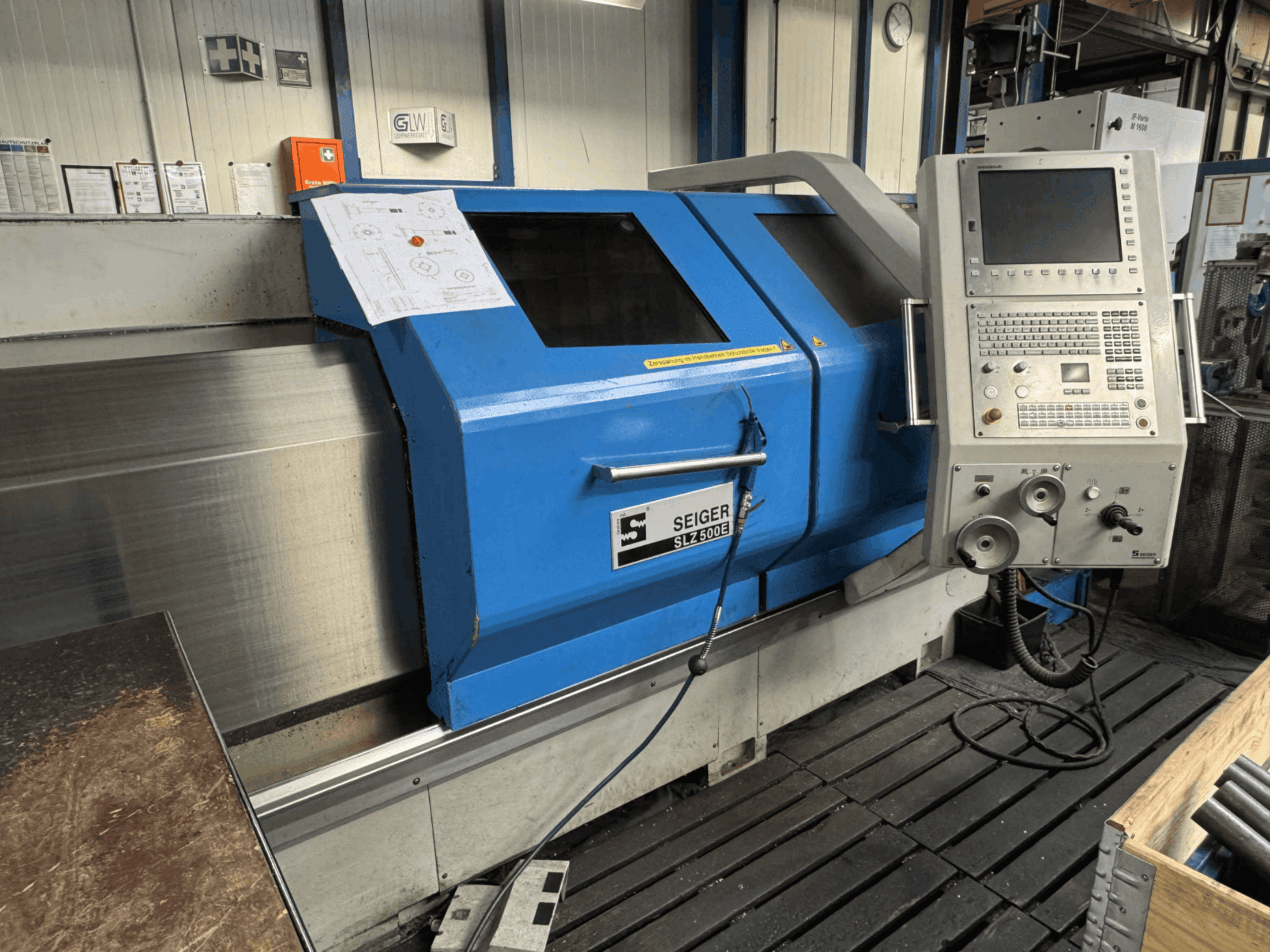 Vista frontal del torno horizontal SEIGER SLZ 500E con panel de control, exterior azul y plano técnico a la vista.