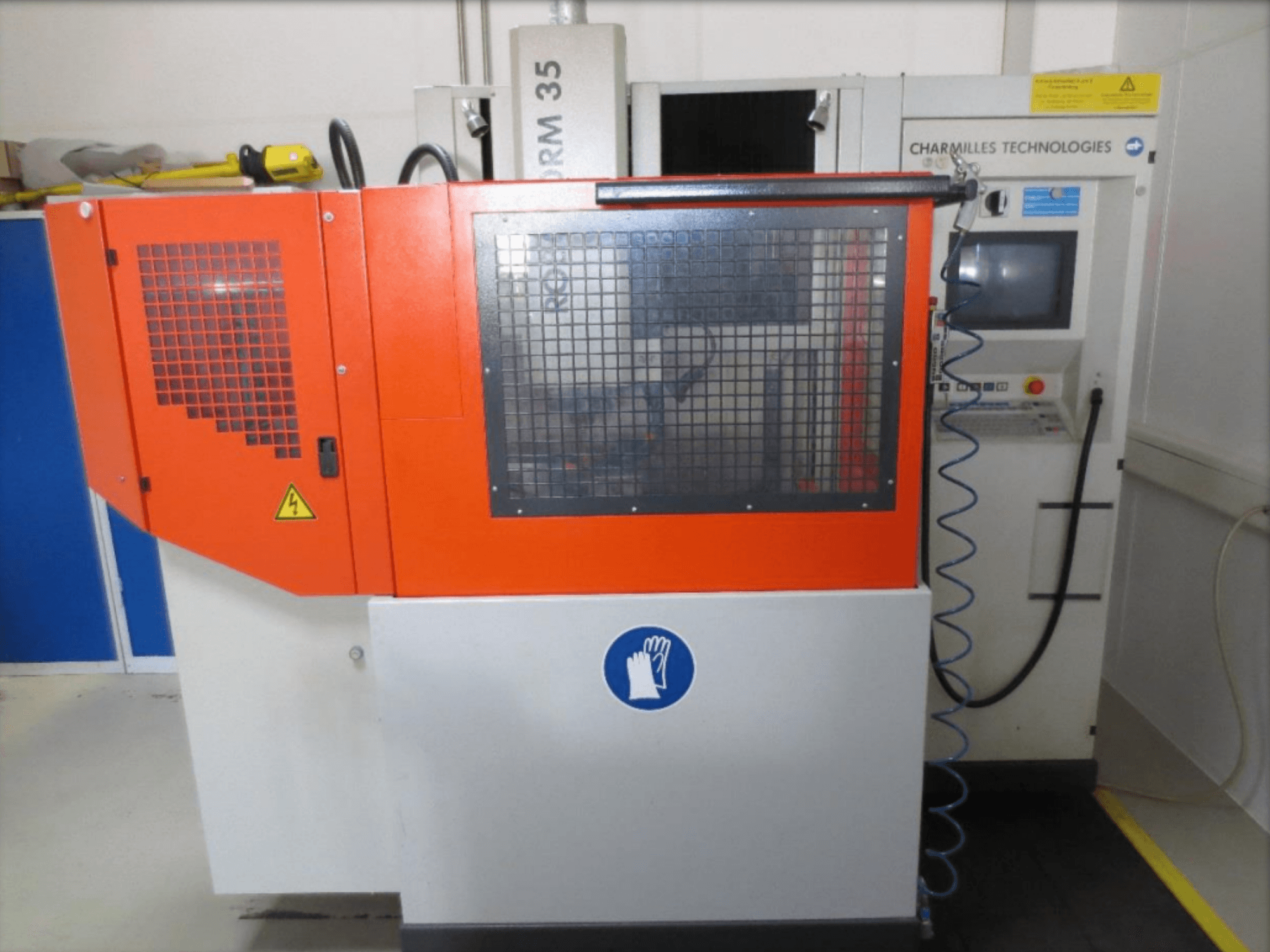 Vista frontal de la máquina de electroerosión por penetración CHARMILLES Roboform 35, en la que se aprecian los paneles rojos y la interfaz de control.