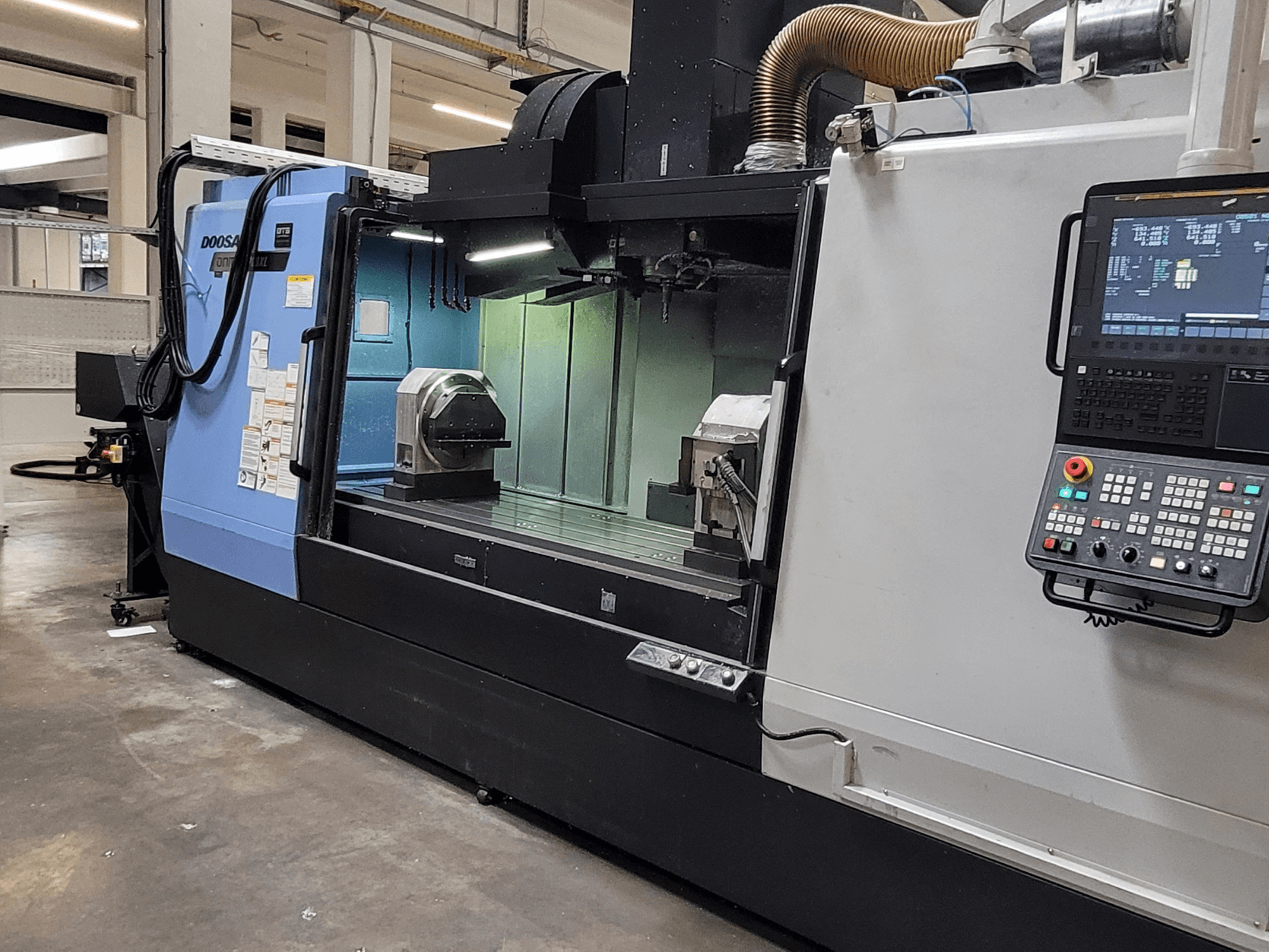 Centro de mecanizado vertical DOOSAN DNM 6700 XL; vista frontal en la que se aprecian el panel de control, la mesa de trabajo y la zona de mecanizado.
