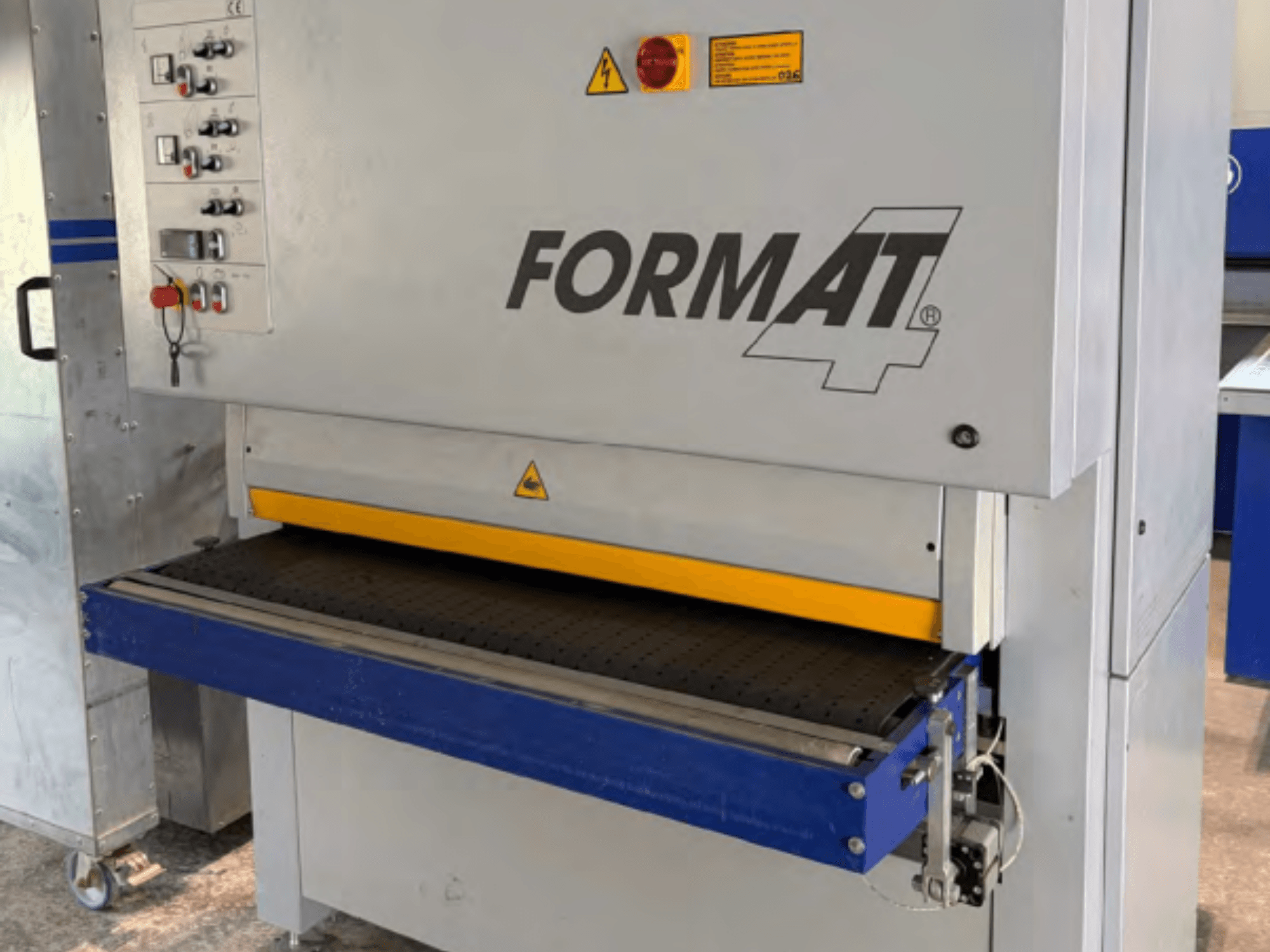 Lijadora de cinta FORMAT4 Finish 1302 vista de frente, con el panel de control, la cinta de lijado amarilla y la mesa transportadora azul.