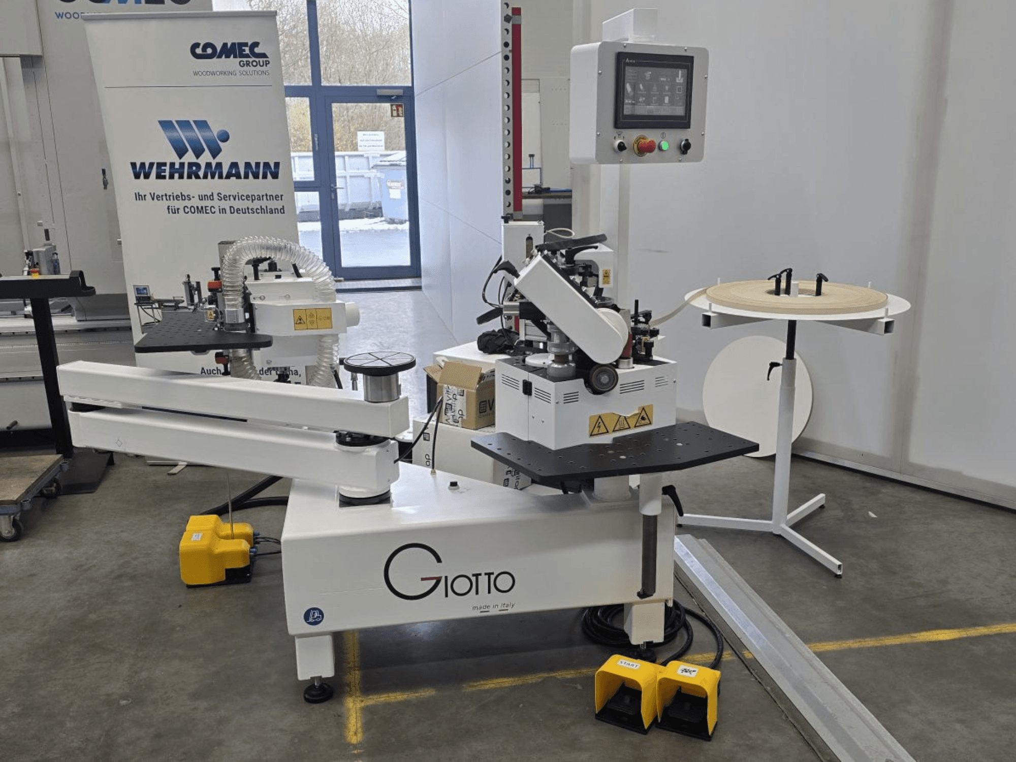 Máquina de procesamiento de madera Giotto con panel de control, vista lateral, incluye pedales y superficie de trabajo giratoria.