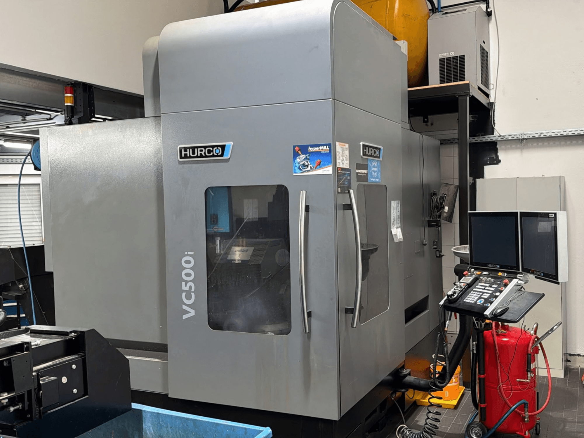 Centro de mecanizado vertical Hurco VC500i, vista frontal en la que se aprecian el panel de control y dos monitores, en un entorno de taller.