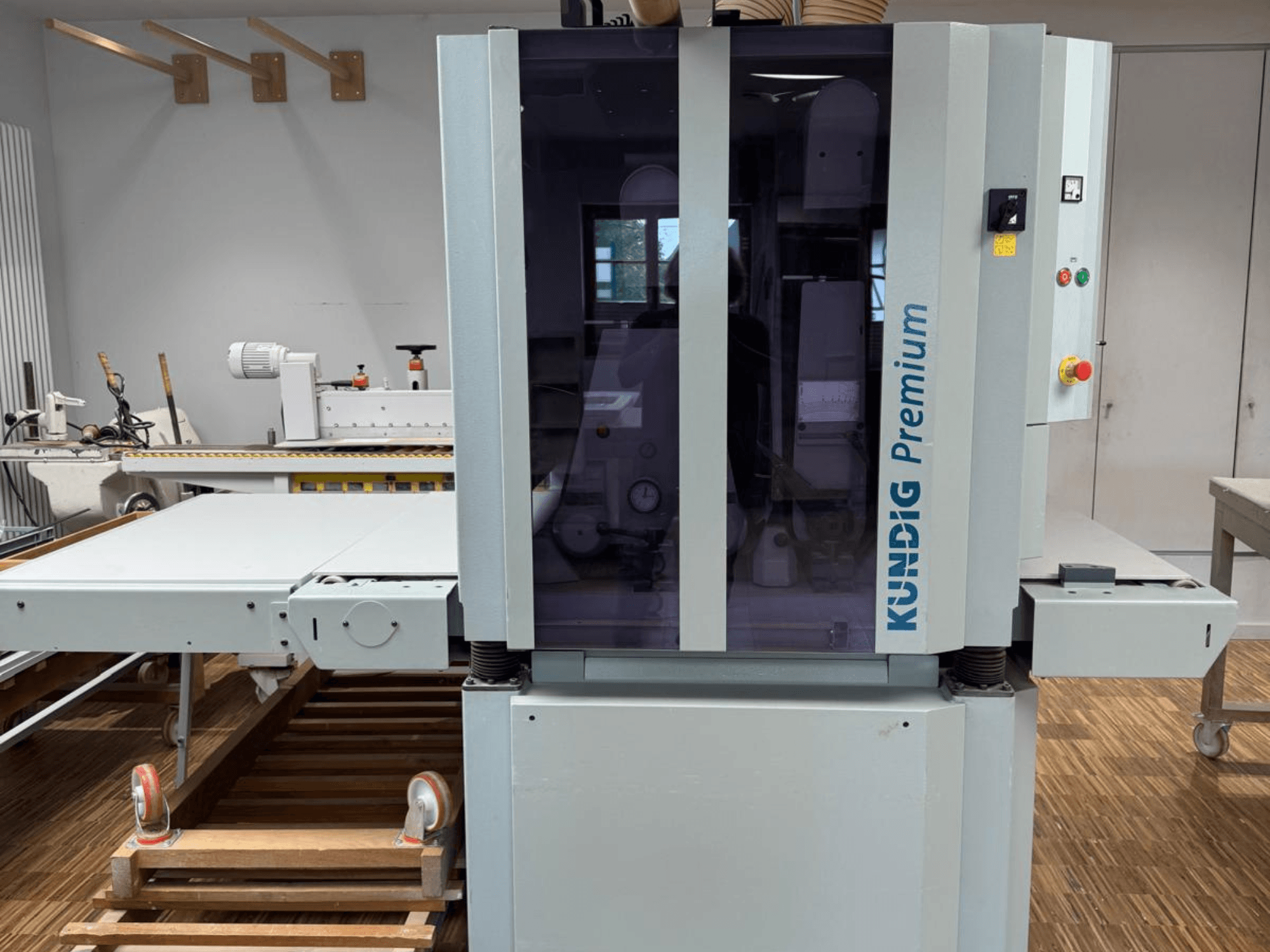 Lijadora de banda Kundig Premium 2-1100-RP en vista frontal con panel de control y gran recinto acristalado para mayor visibilidad.