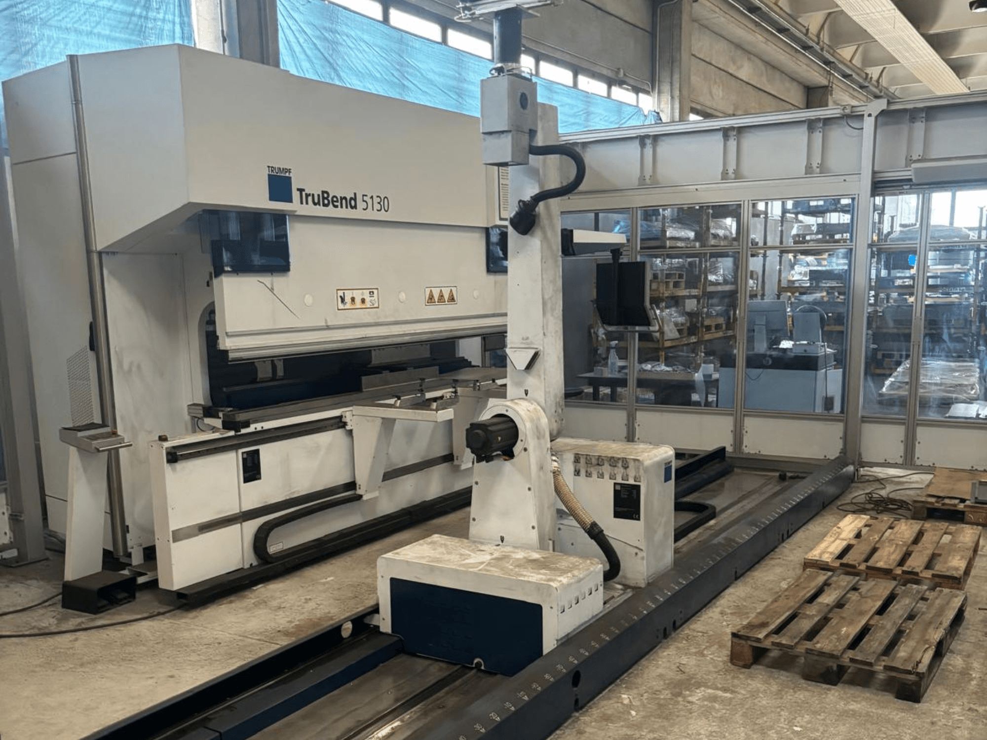 Plegadora TruBend 5130 de Trumpf, vista frontal, con panel de control y palés en un entorno de fábrica.