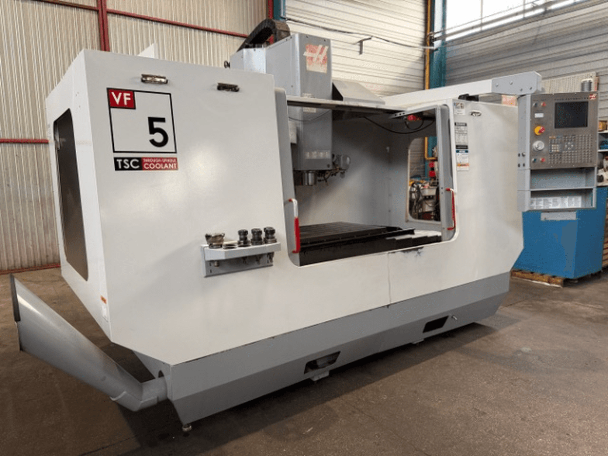 Centro de mecanizado vertical HAAS VF5-HE, vista frontal, en la que se aprecian el sistema de refrigeración TSC y el panel de control del operador.