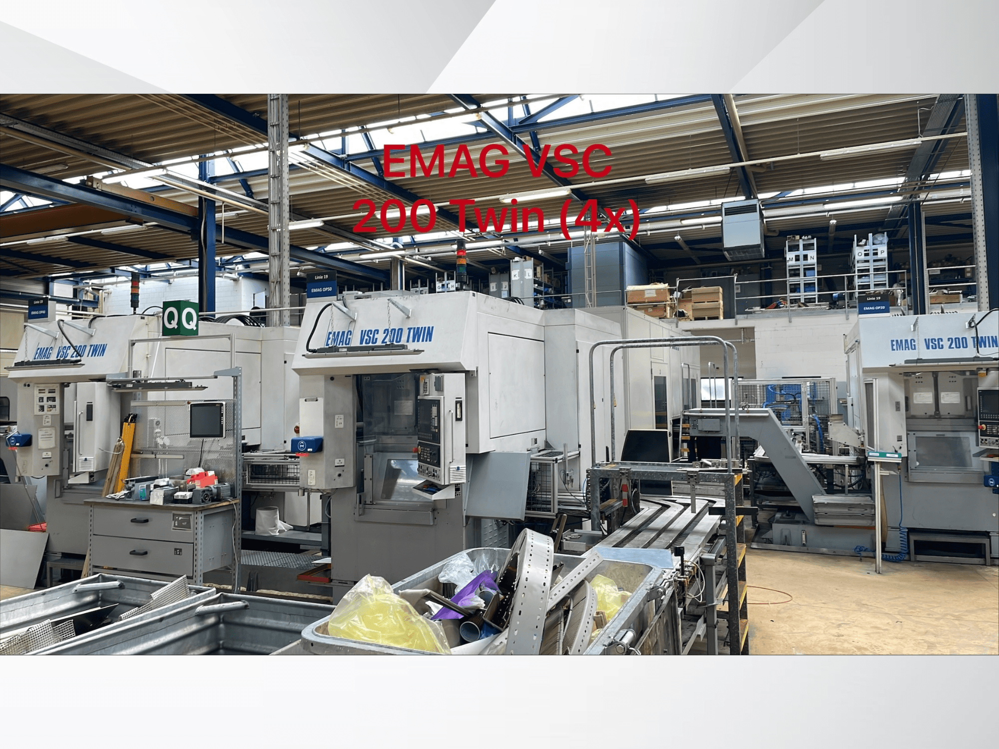 Vista frontal de los tornos verticales EMAG VSC 200 TWIN en un taller, mostrando cuatro unidades con diversos equipos de manipulación de herramientas.
