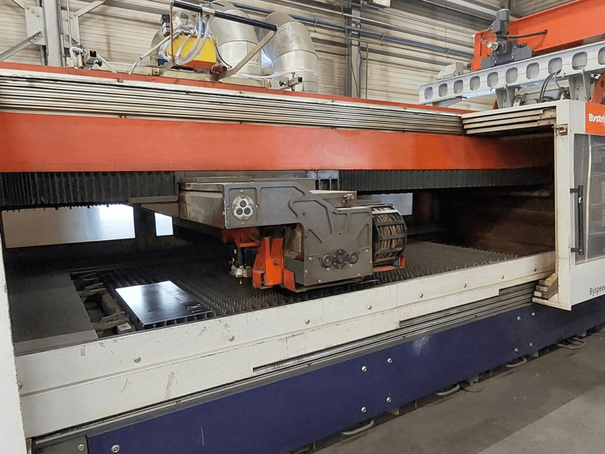 Máquina de corte por láser de CO₂ Bystronic BySpeed 3015; vista frontal en la que se aprecian el cabezal de corte y la chapa metálica sobre la mesa de corte.