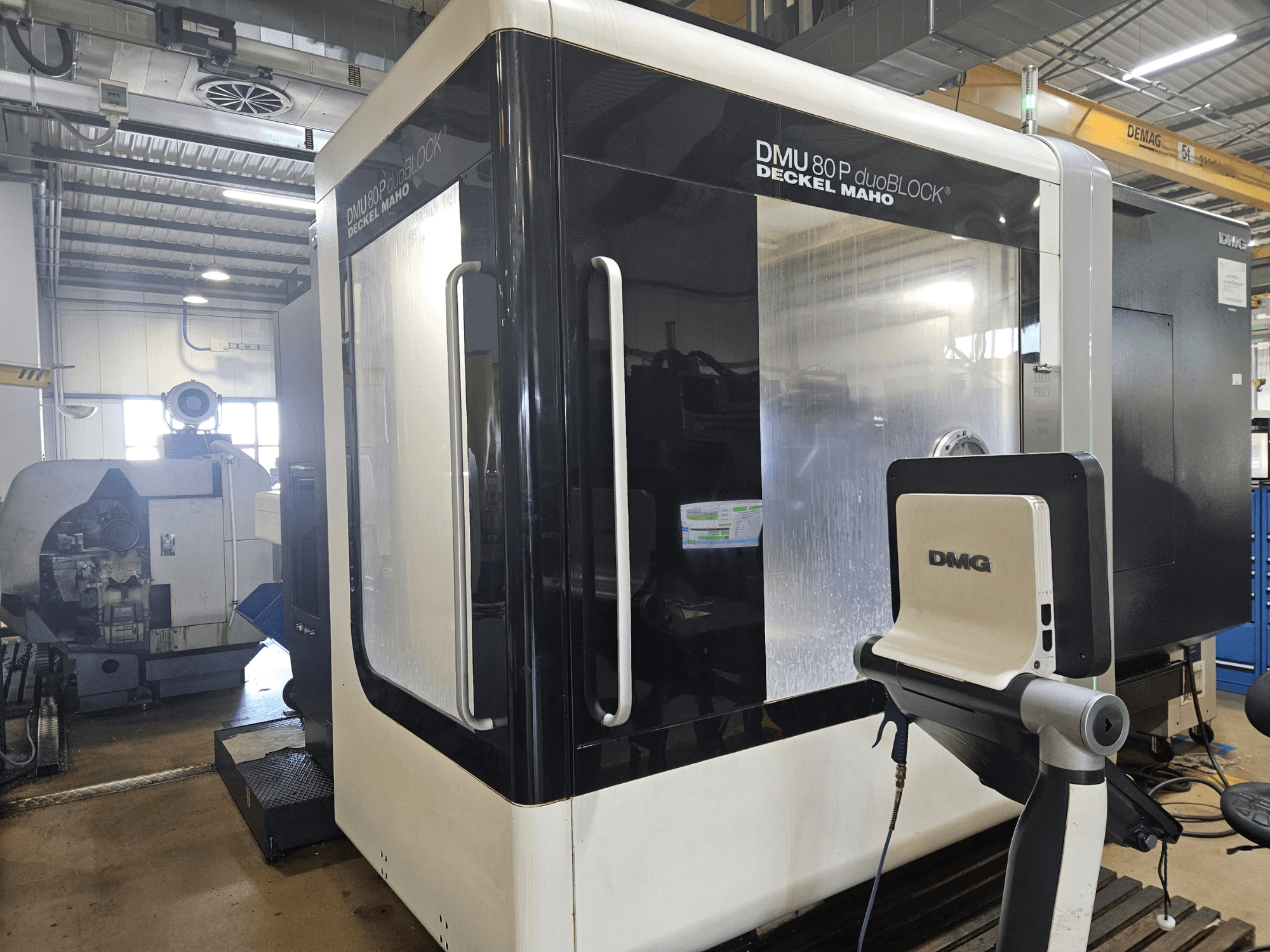 Centro de mecanizado vertical DMU 80P duoBLOCK de DMG DECKEL MAHO, vista frontal, con doble acceso y panel de control en configuración de fábrica.