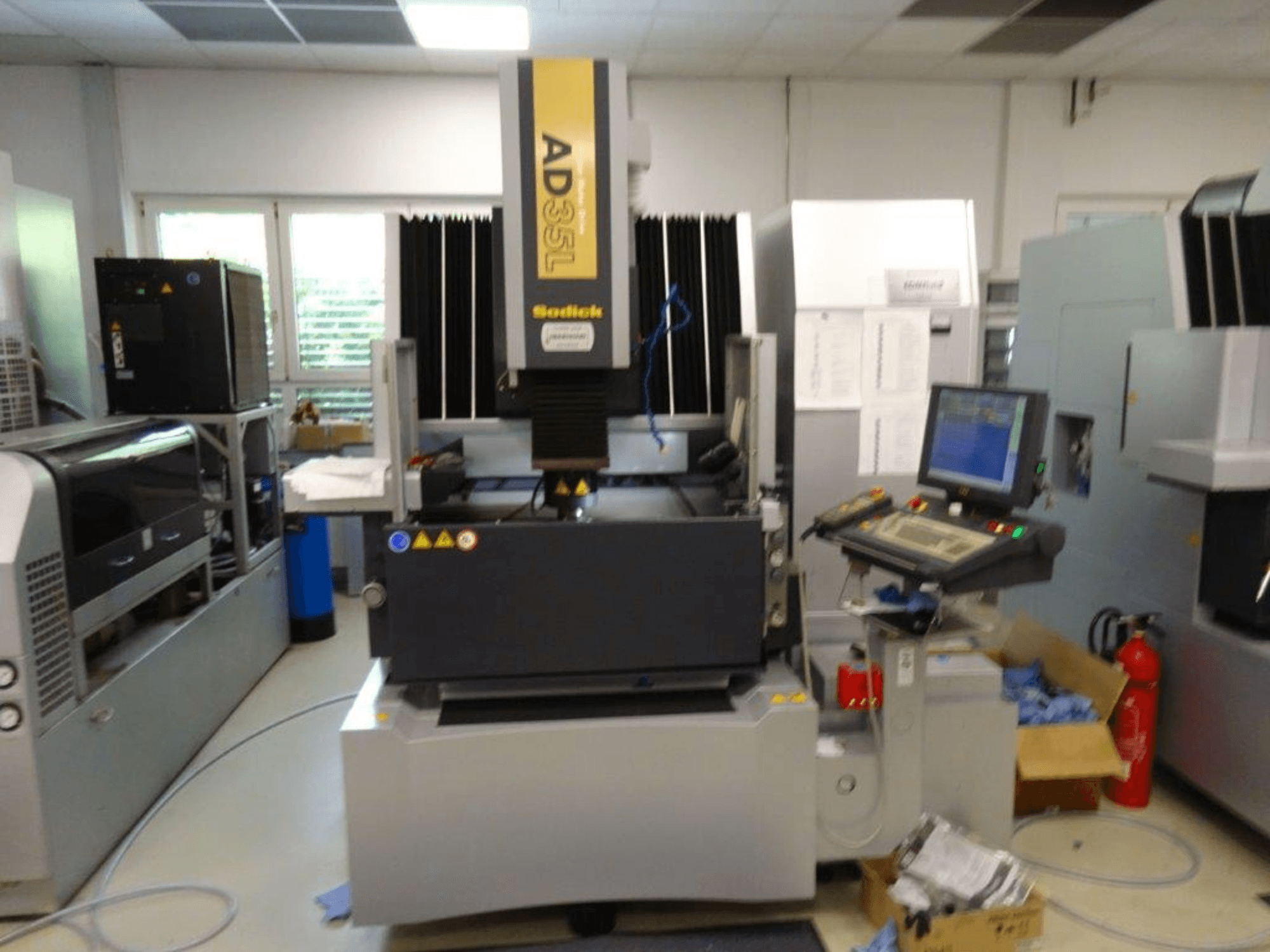 Máquina CNC Sodick AD35L vista frontal, con panel de control, unidad de refrigeración e indicadores de seguridad.