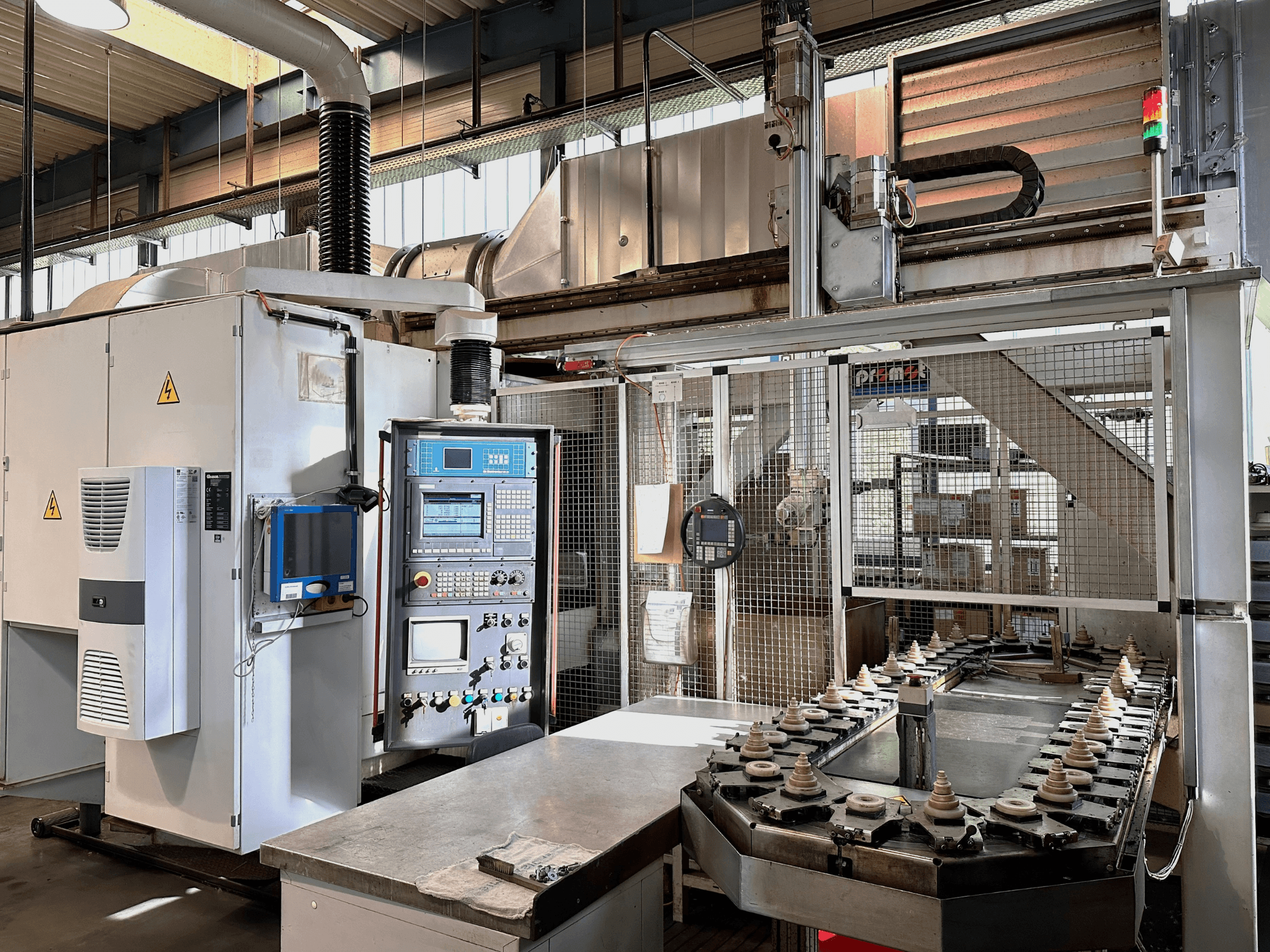 Maquinaria industrial con panel de control, unidad de refrigeración y cinta transportadora. Vista frontal, con luces brillantes y señalización de seguridad.