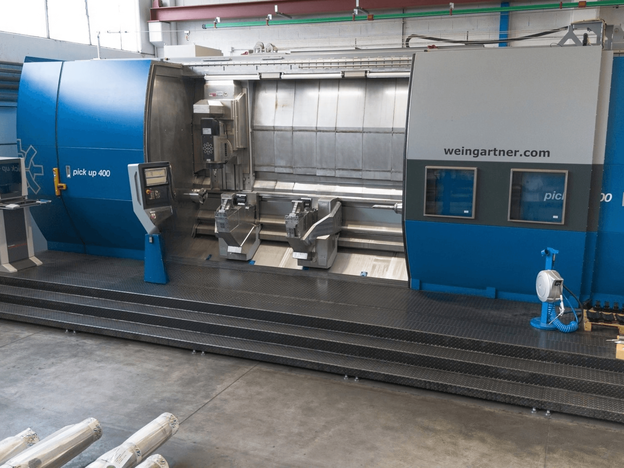 Centro de torneado y fresado Weingartner Pick Up 400, vista frontal. Cuenta con dos puestos de trabajo y un panel de control; entorno industrial.