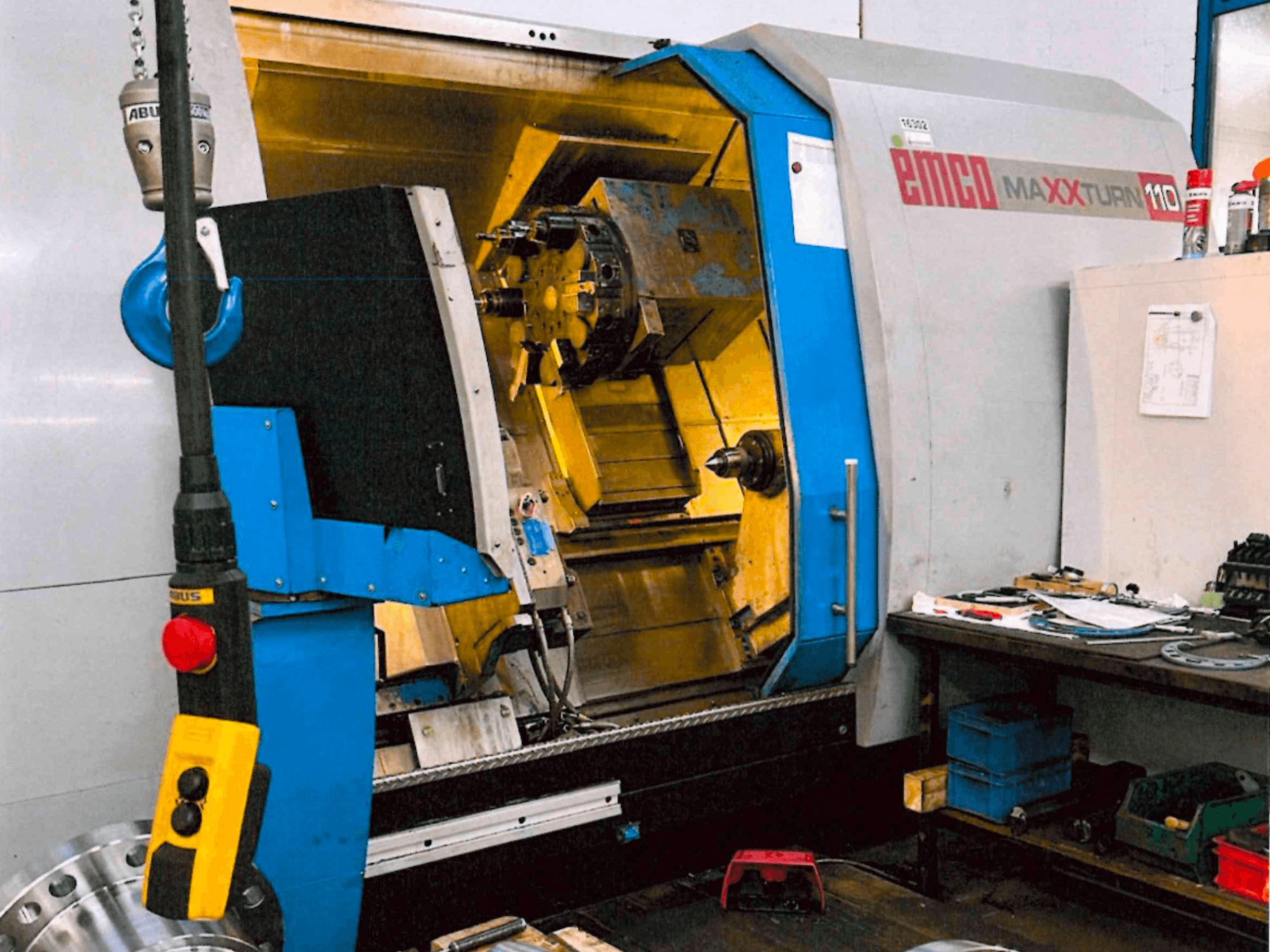 Torno horizontal EMCO MAXTURN 110, vista frontal, en la que se aprecian los componentes internos y el panel de control, en un entorno de taller.