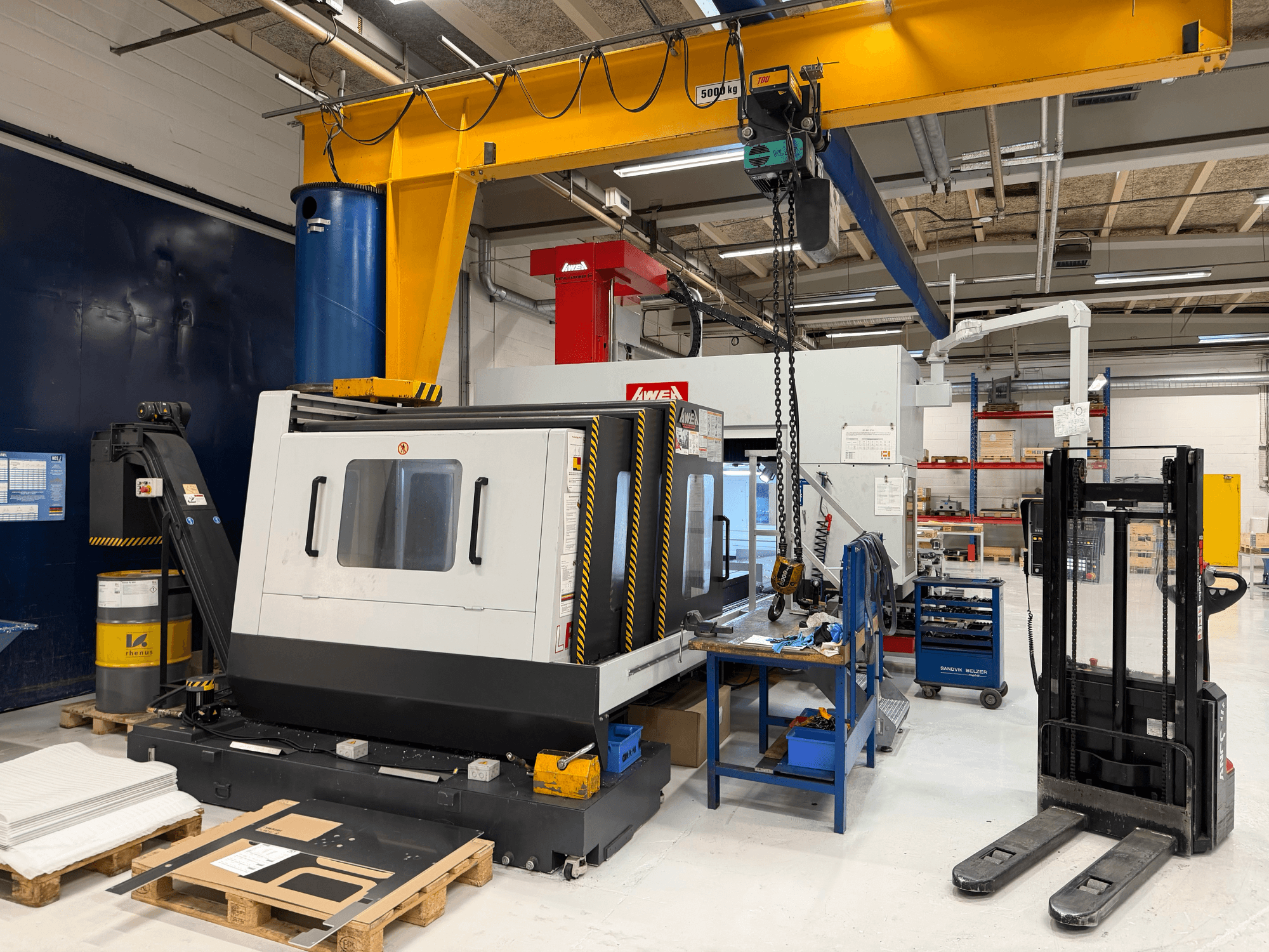 Fresadora de pórtico AWEA LP3016YF, vista frontal, con herramientas, depósito azul y espacio de trabajo al fondo.