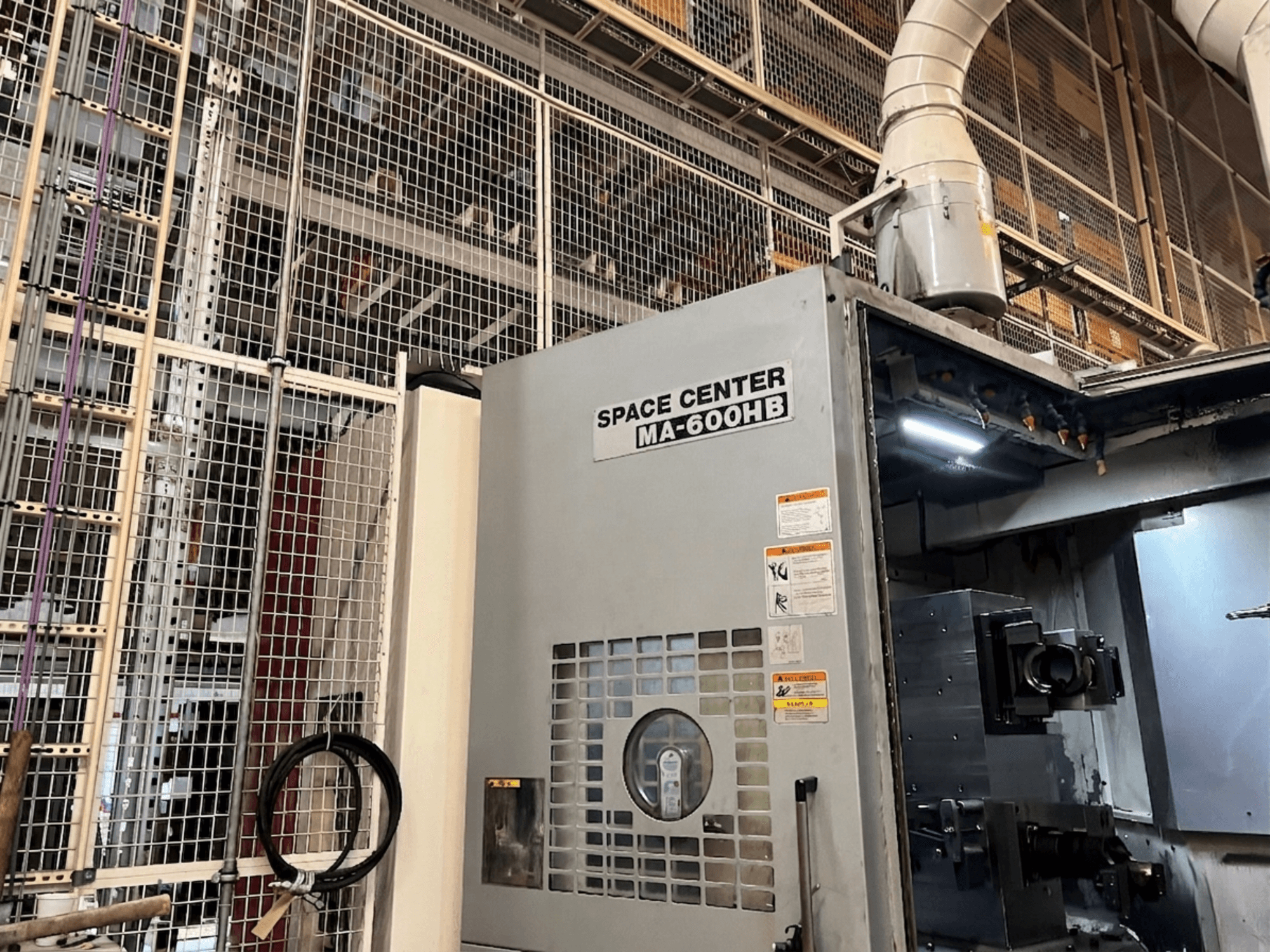 Centro de mecanizado horizontal Okuma MA-600HB, vista frontal, con el panel operativo y las boquillas de refrigerante visibles.