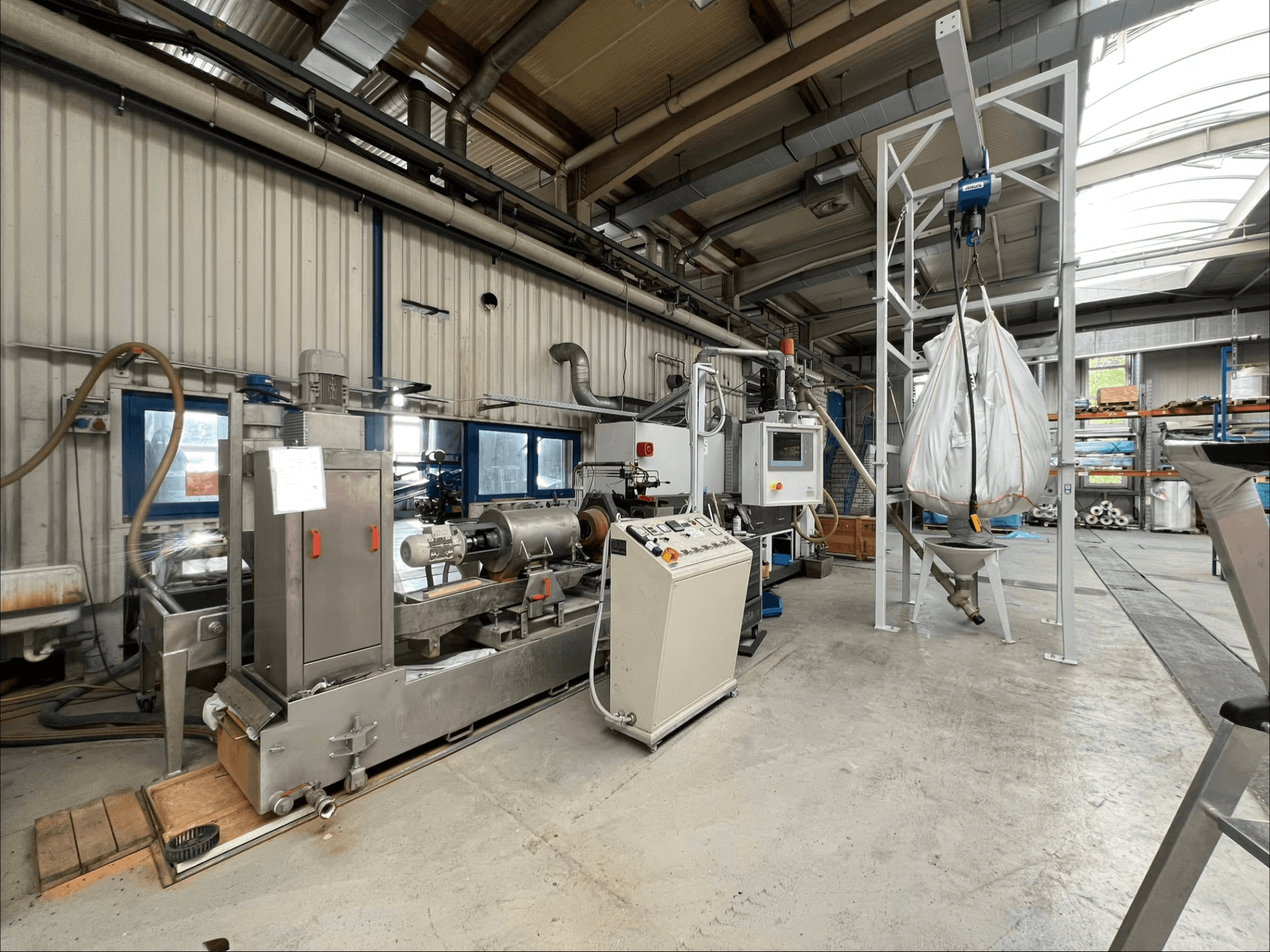 Vista frontal de la máquina de procesamiento de plástico FILTEC GRP 350 en un entorno industrial, en la que se aprecian los mandos y el sistema de alimentación.