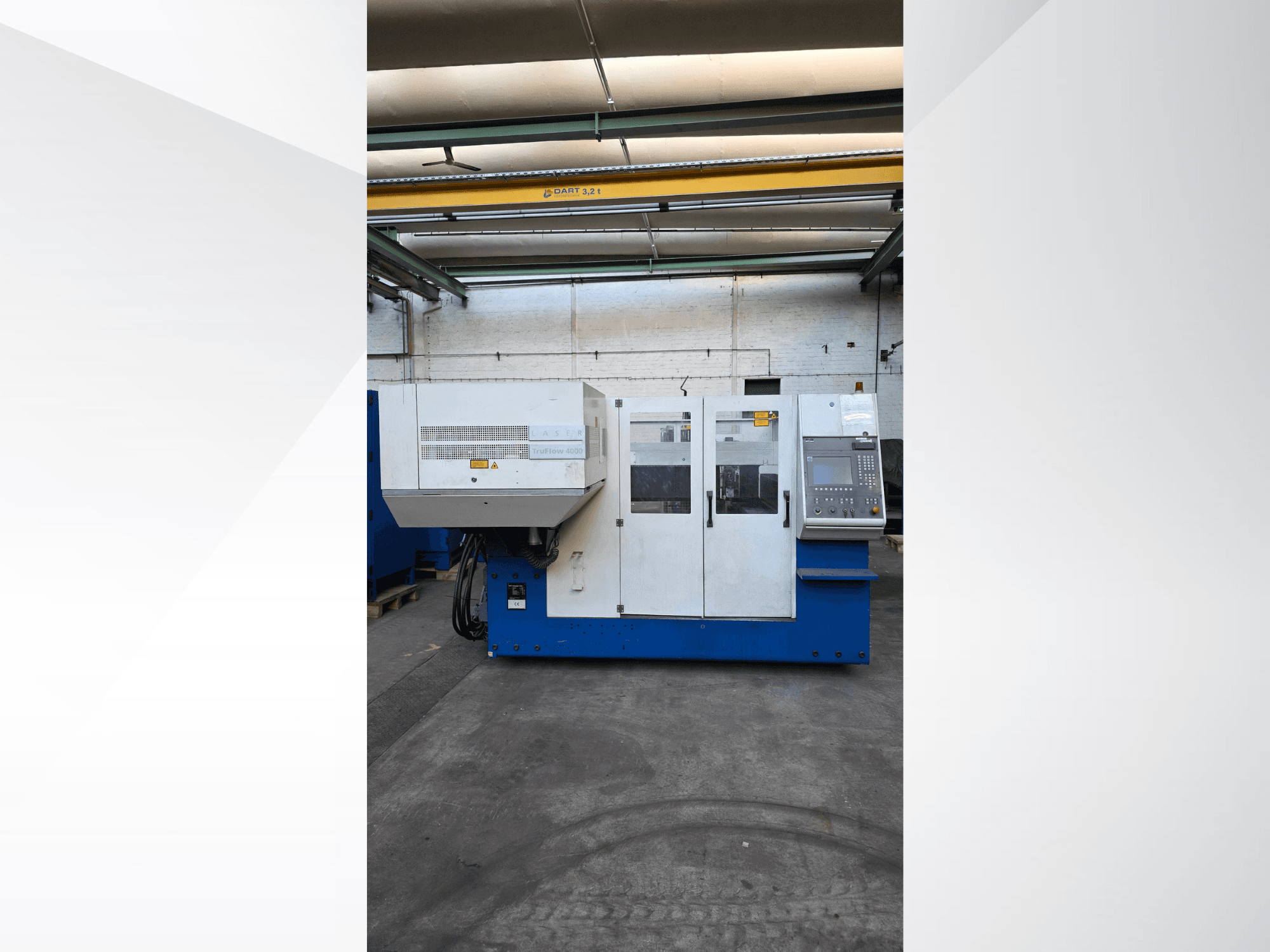 Máquina de corte por láser de CO2 TRUMPF TruLaser 3030, vista frontal, con panel de control y advertencias de seguridad en el exterior.