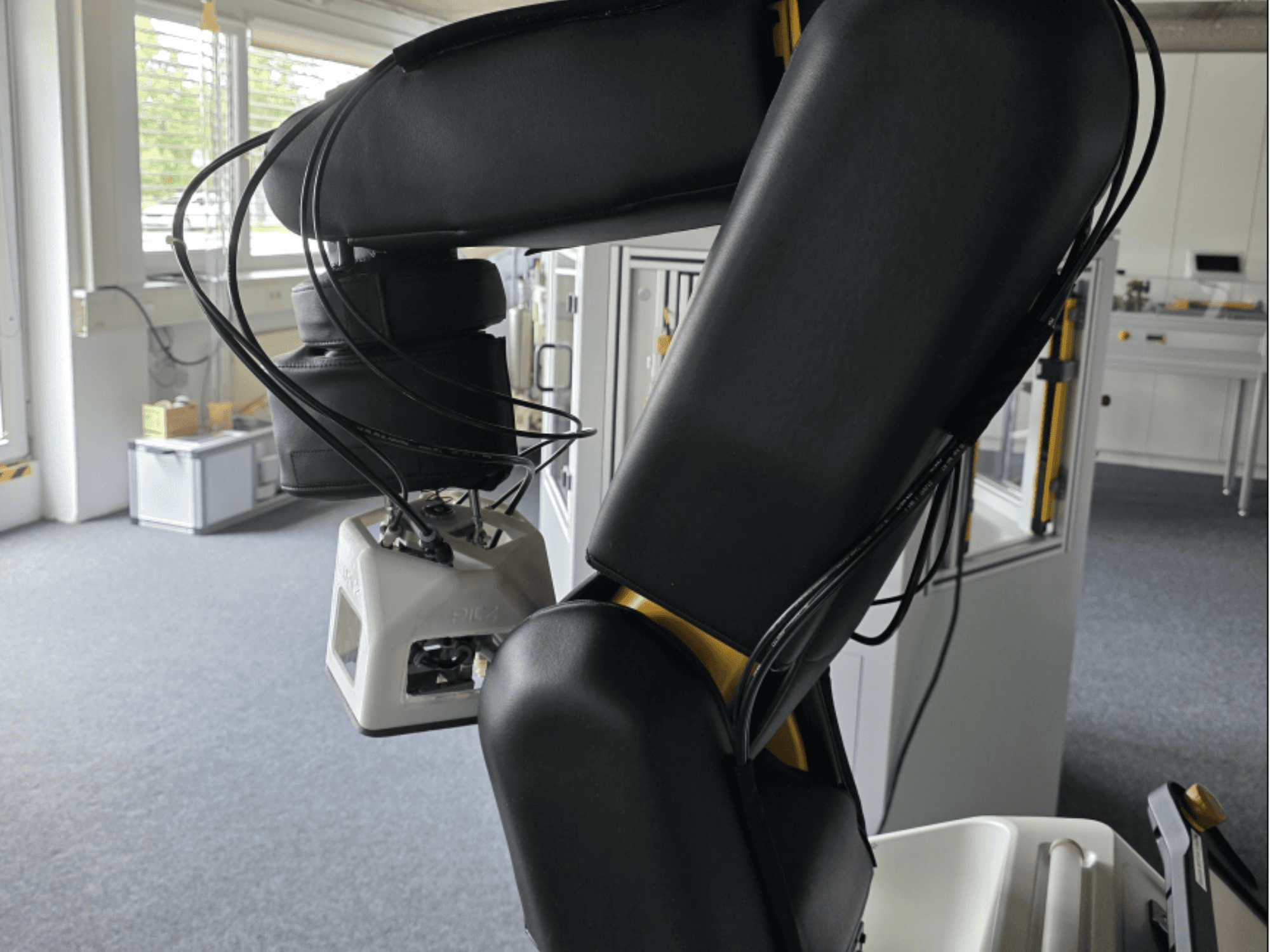 Vista lateral del robot colaborativo FANUC LR Mate 200iD/7L, en la que se aprecian el brazo y los sensores, así como los cables, en un entorno de taller.