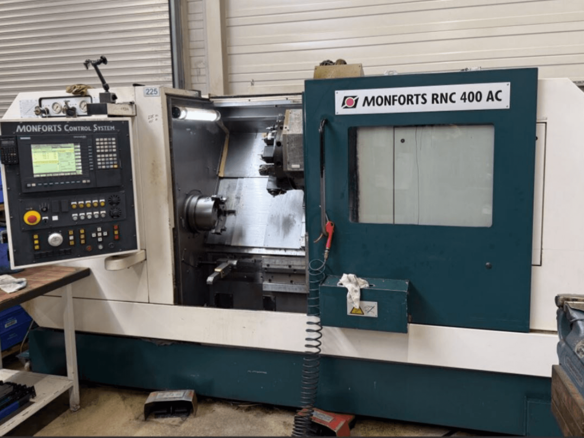 Máquina de torneado horizontal Monforts RNC 400 AC, vista frontal, mostrando el panel de control y la zona de mecanizado con herramientas visibles.