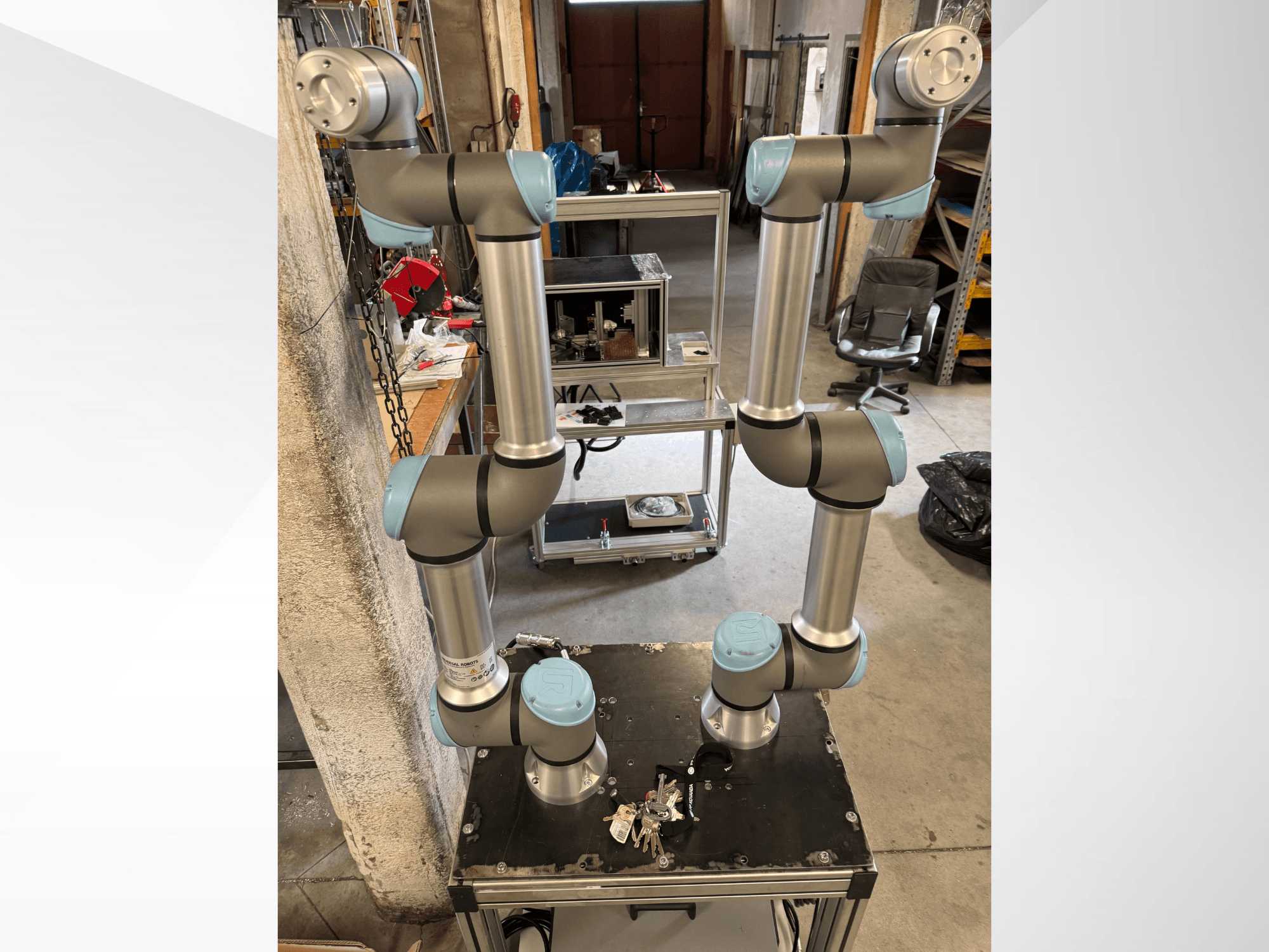 Brazo robótico Universal Robots UR5e mostrado desde una vista frontal, con seis articulaciones con secciones grises y azules, montado sobre una plataforma negra.