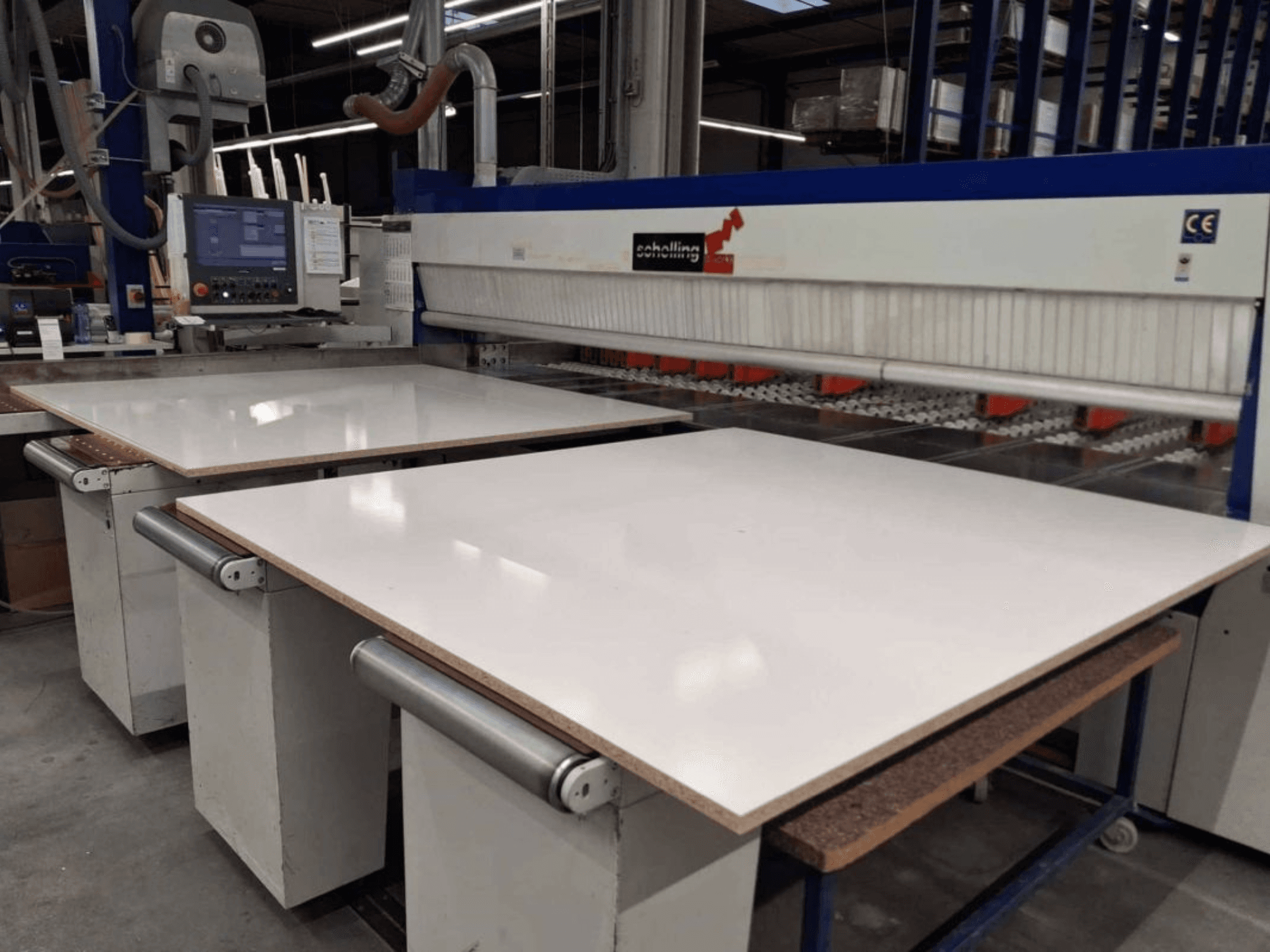 Vista frontal de la seccionadora SCHELLING FM-H 430 con la mesa de corte blanca, el panel de control y la zona de la hoja de sierra visibles.