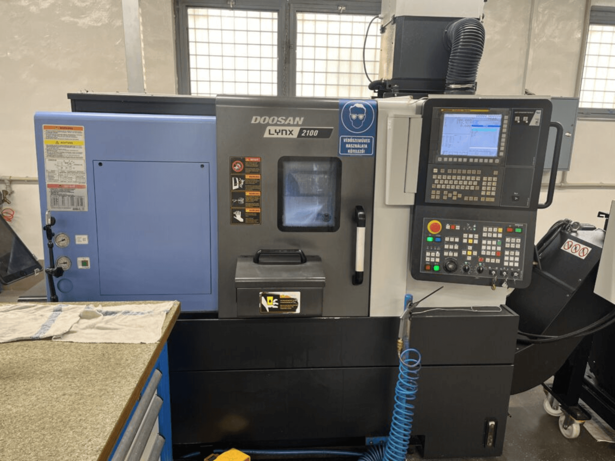 Máquina de torneado horizontal DOOSAN Lynx 2100A, vista frontal que muestra el panel de control, la interfaz del operario y las características de la máquina.