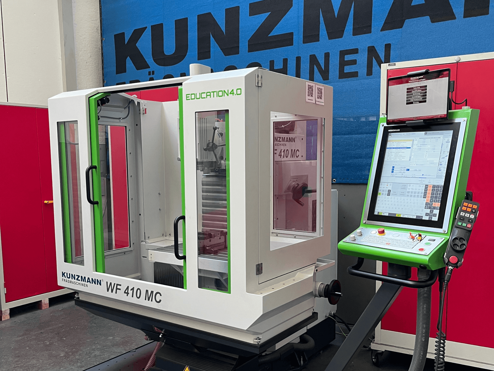 Centro de mecanizado universal KUNZMANN WF 410 MC en vista frontal, en el que destacan los detalles en verde, las puertas transparentes y el panel de control.