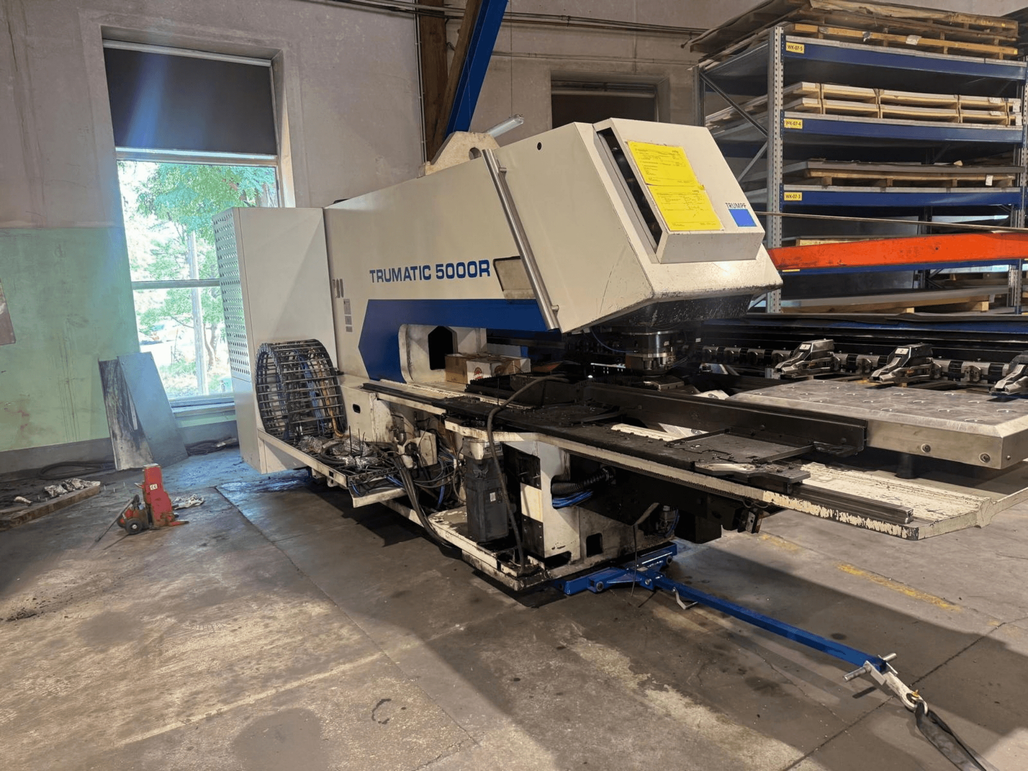 Máquina punzonadora CNC TRUMPF TRUMATIC 5000R en un taller, vista frontal en la que se aprecian sus mandos y la zona de punzonado.