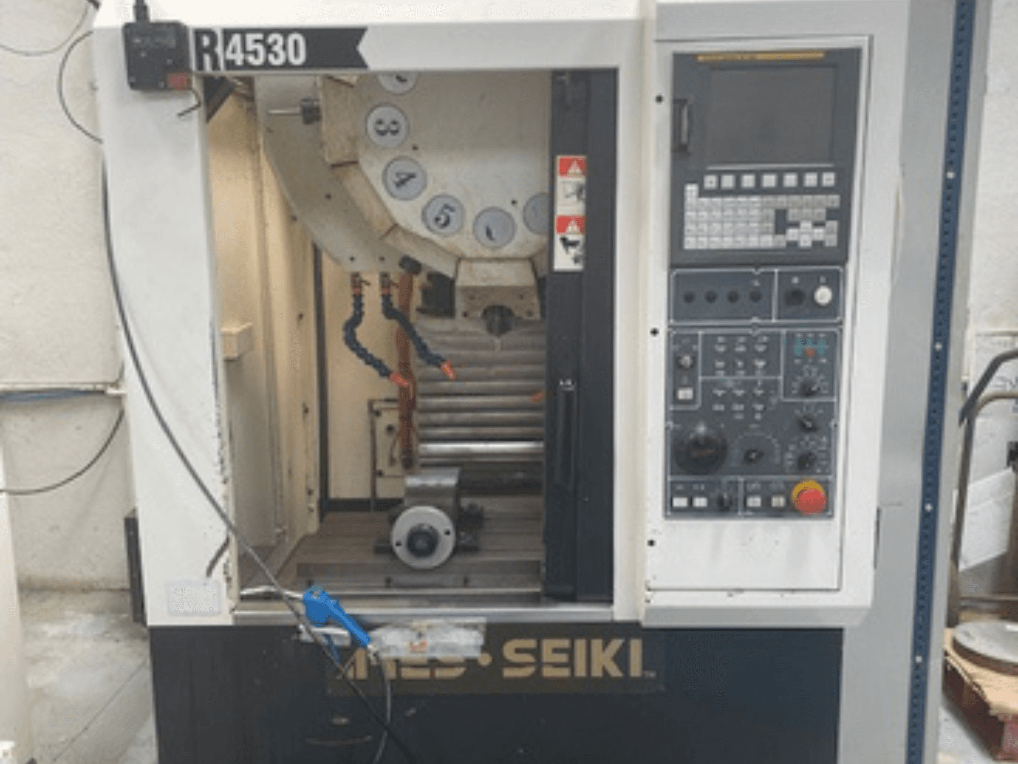 Centro de mecanizado vertical ARES-SEIKI R4530, vista frontal mostrando el panel de control y el área de trabajo con el husillo y el sistema de refrigeración.